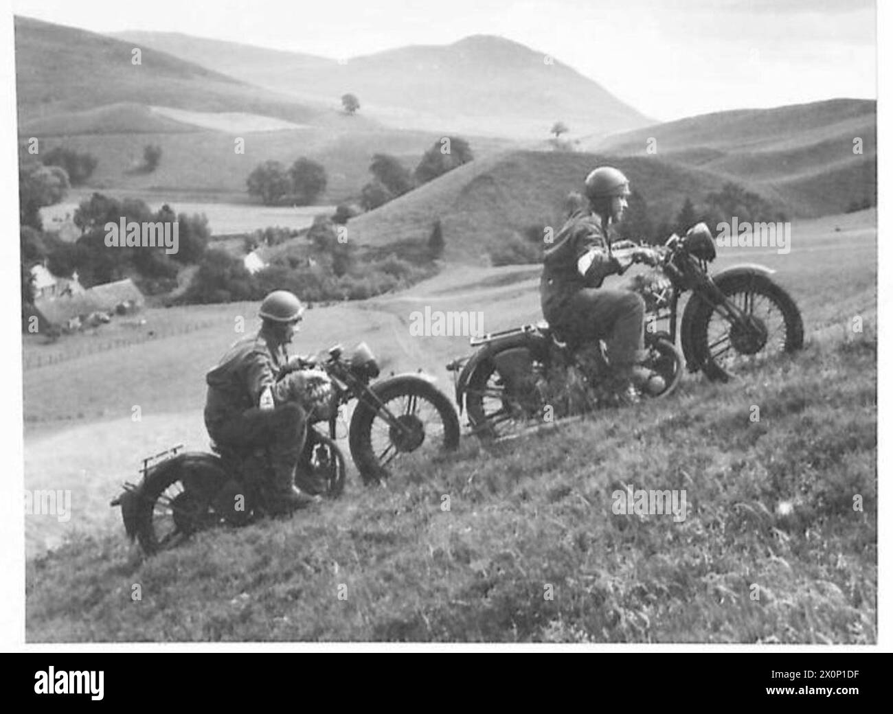 Due motociclisti stanno salendo una collina durante una prova in un tipico paesaggio scozzese. L'immagine è un negativo fotografico dell'esercito britannico. Foto Stock