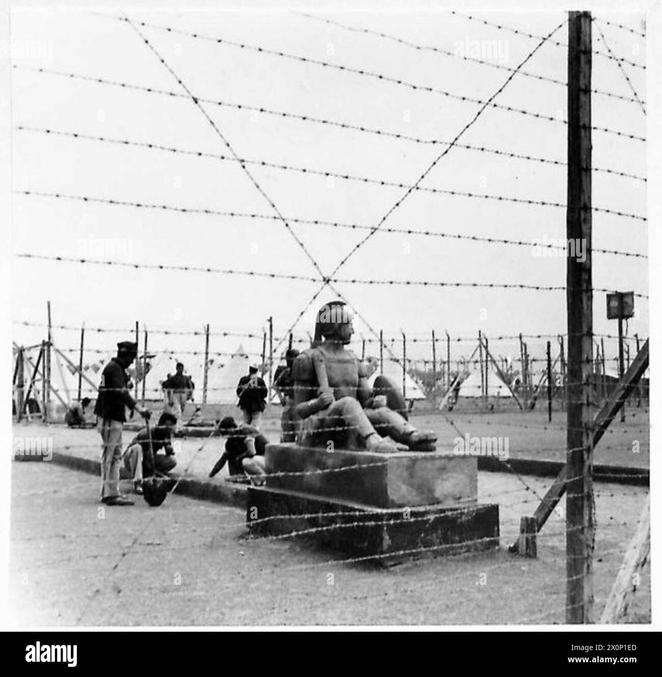 I prigionieri in un campo di prigionia creano una statua intitolata "Italia", vista attraverso il cavo del loro recinto. La scena è registrata in un negativo fotografico dell'esercito britannico. Foto Stock