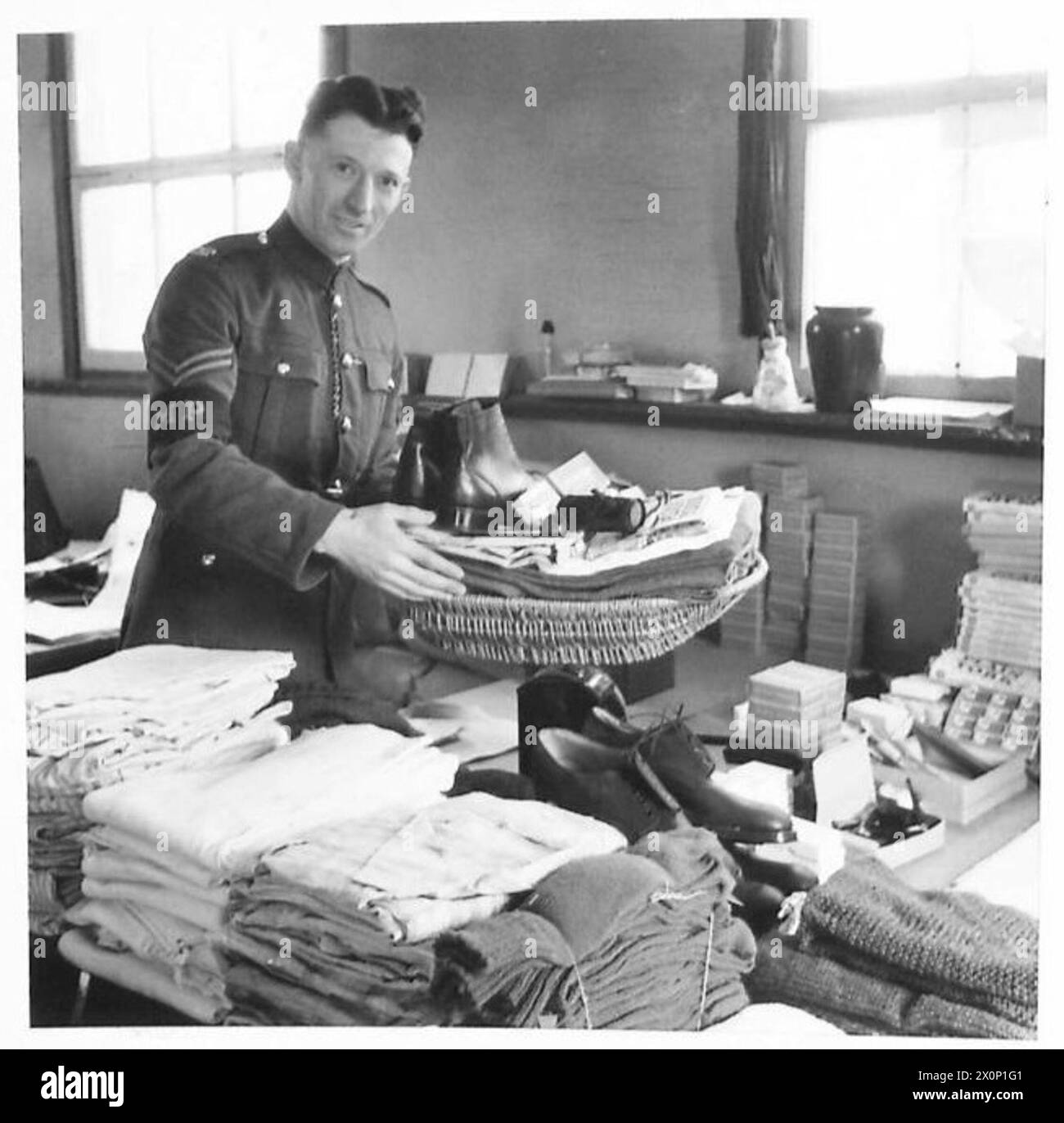 Un operaio dell'esercito britannico pesa il contenuto di un pacco destinato ai prigionieri di guerra della polizia militare prima di imballare. Il negativo fotografico mostra il processo di preparazione dei pacchi per la consegna. Foto Stock