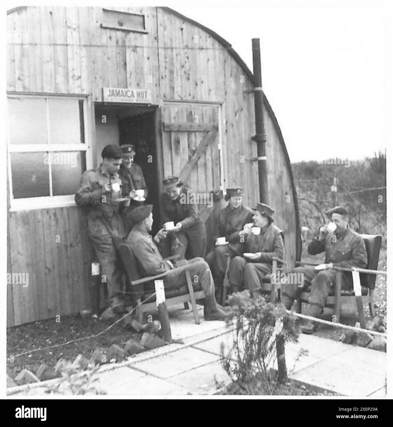 Il personale antiaereo si goderà una tazza di tè fuori da una capanna di ricreazione, conosciuta come la capanna Giamaica, su un sito di armi da fuoco. Negativo fotografico, British Army. Foto Stock