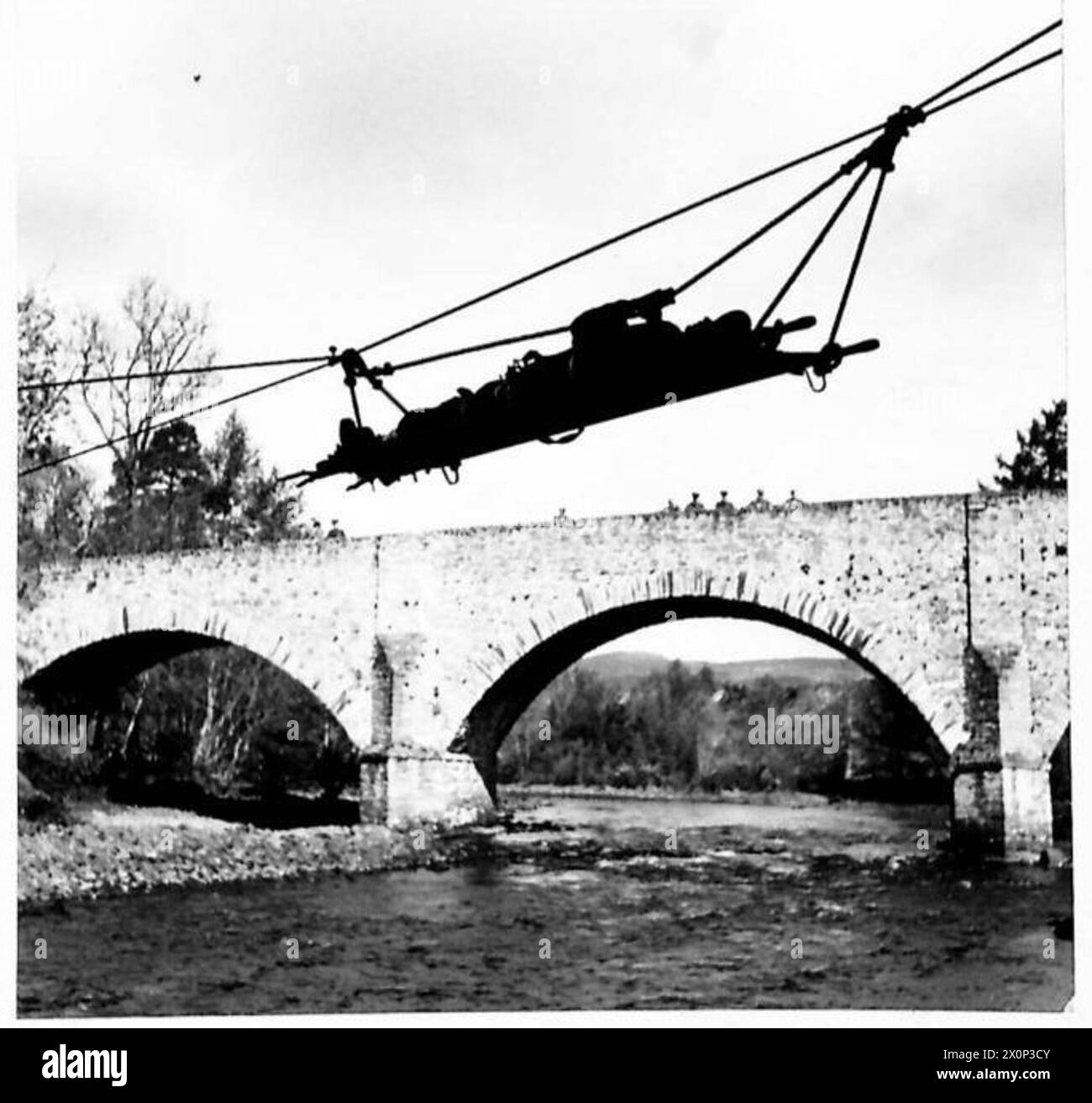Il generale Bernard C.T. Paget osserva che una barella viene trasportata attraverso un fiume usando corde attaccate agli alberi durante un esercizio in Scozia. Negativo fotografico. Foto Stock