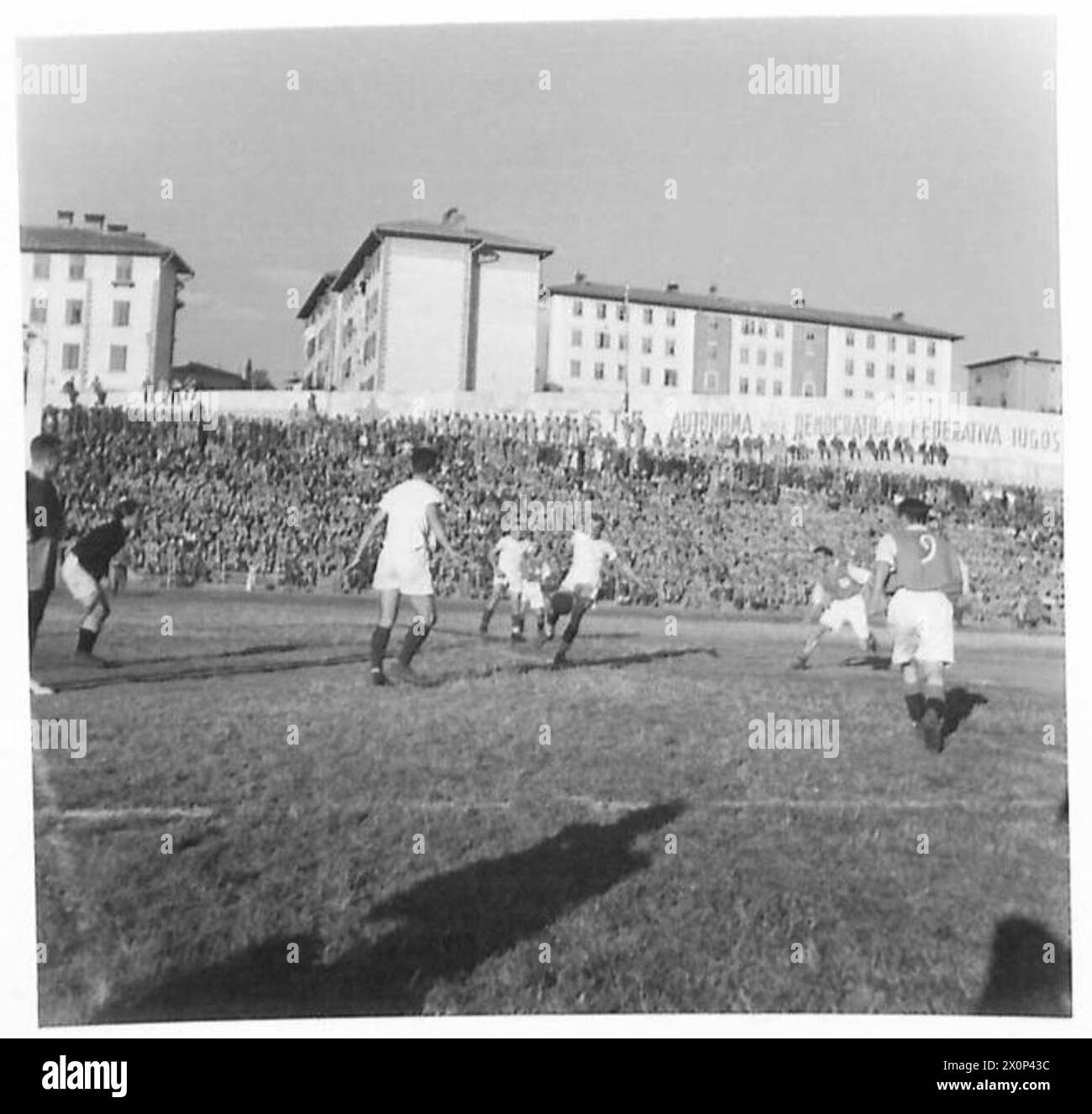 I soldati britannici e jugoslavi sono raffigurati giocare a calcio vicino alla bocca di porta jugoslava. Il caporale H. Jones del quartier generale del corpo ha segnato entrambi i gol per 13 Corps. Negativo fotografico, British Army. Foto Stock