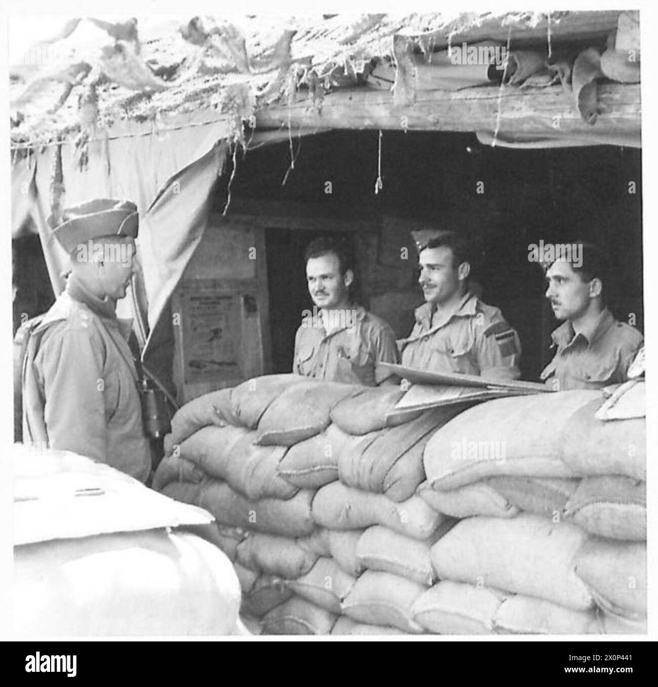 Il generale Devers visita il fronte italiano orientale e parla con i cannoni canadesi che utilizzano una batteria d'artiglieria da 25 libbre. Foto Stock