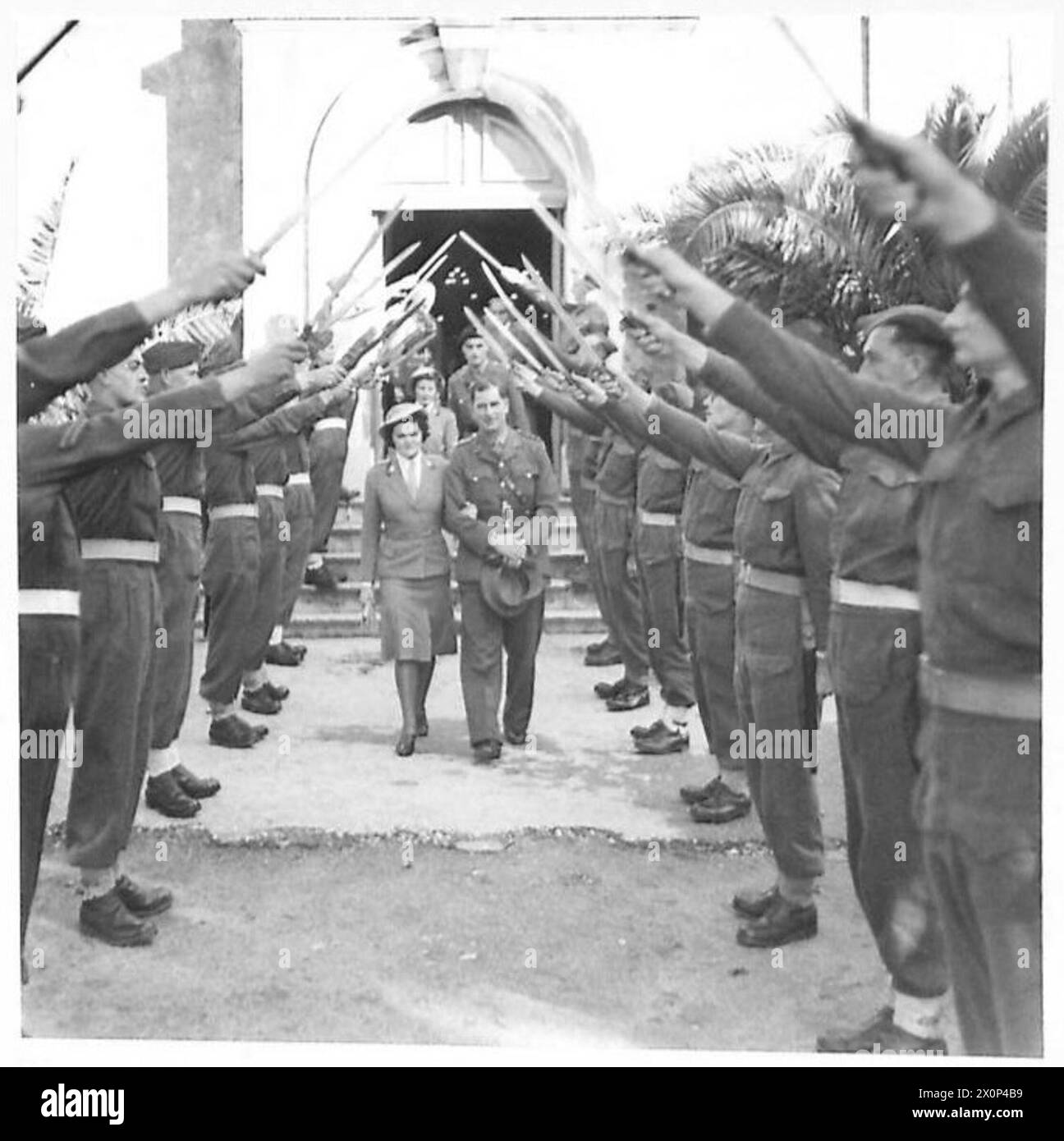 Un negativo fotografico che mostra una sposa e uno sposo che passano la Guardia d'Onore dopo la cerimonia di nozze durante il servizio attivo in Nord Africa. Foto Stock