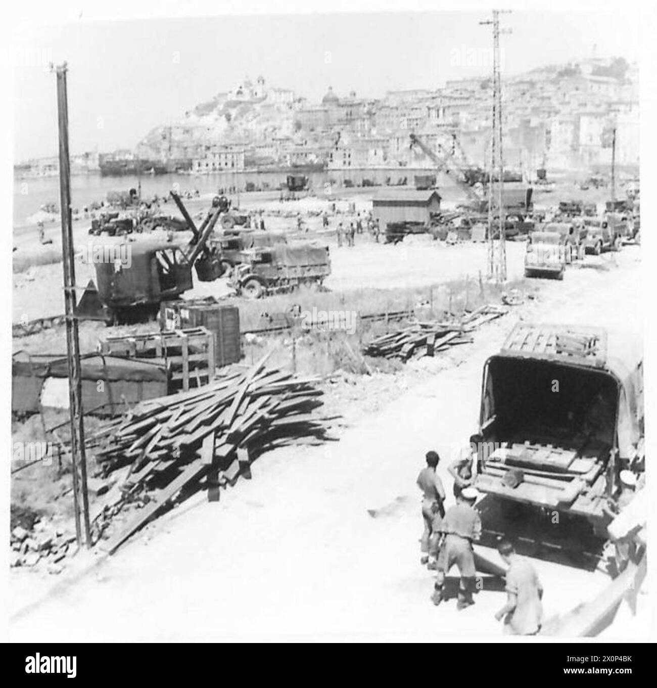 Bulldozer e gru preparano la banchina di Ancona per scaricare i negozi navali per l'Ottava Armata. Negativo fotografico dell'esercito britannico. Foto Stock