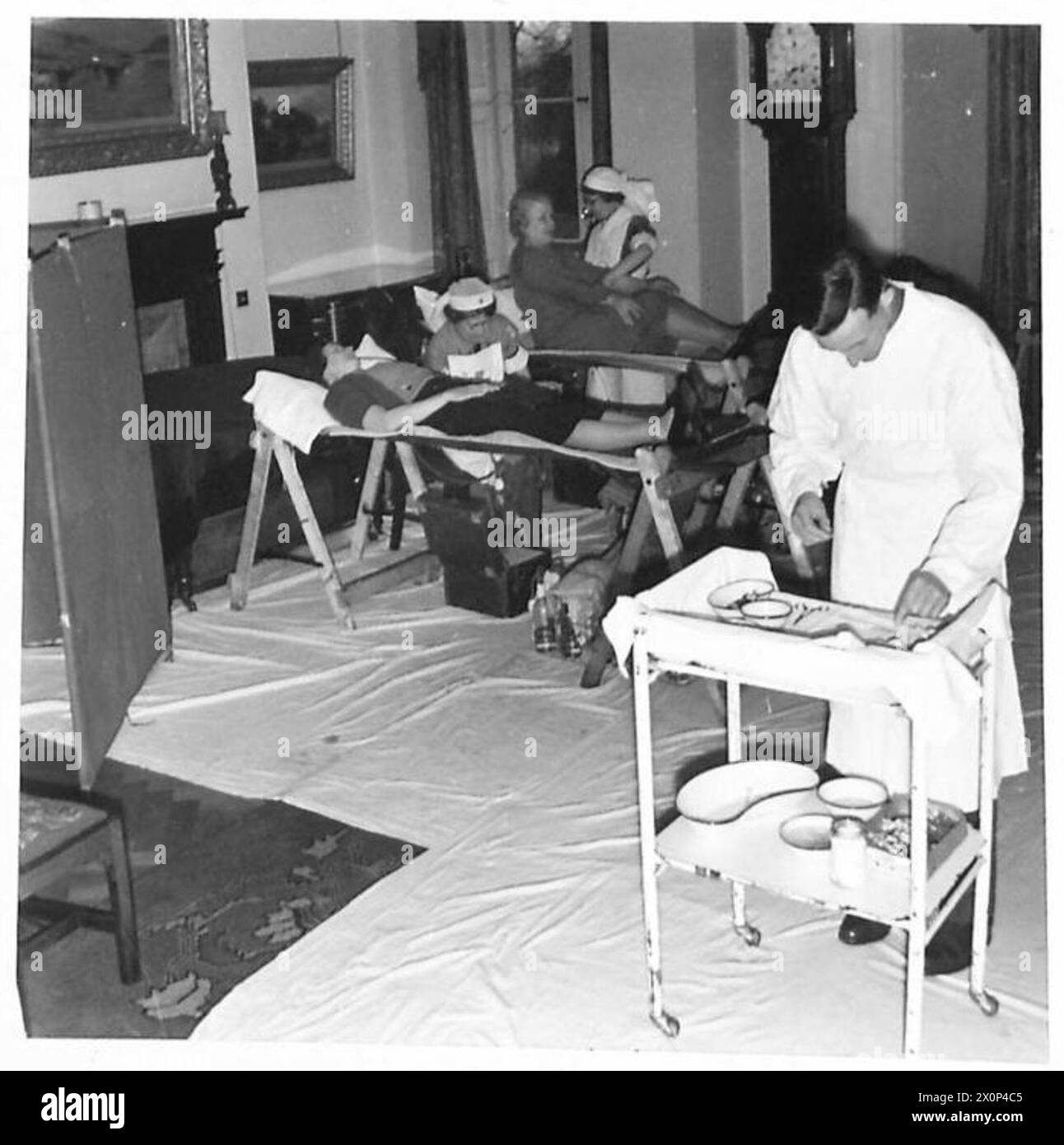 Le unità mobili dell'Army Blood Transfusion Service installano attrezzature in fabbriche, sale parrocchiali, scuole o case private dove i donatori donano il sangue, documentate in un negativo fotografico dell'esercito britannico. Foto Stock