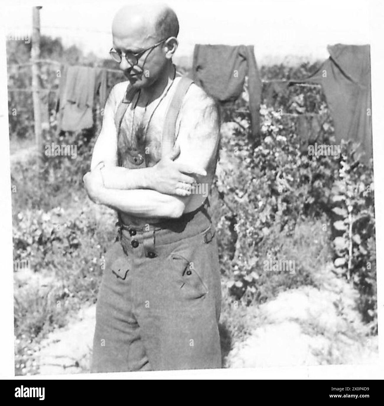 La fotografia mostra Rudolf Greishammer, un ex Dottore in filosofia dell'Università di Jena in Turingia, Germania, che serve come fante nell'esercito tedesco, togliendo i pidocchi dai suoi vestiti, catturato come negativo fotografico. Foto Stock