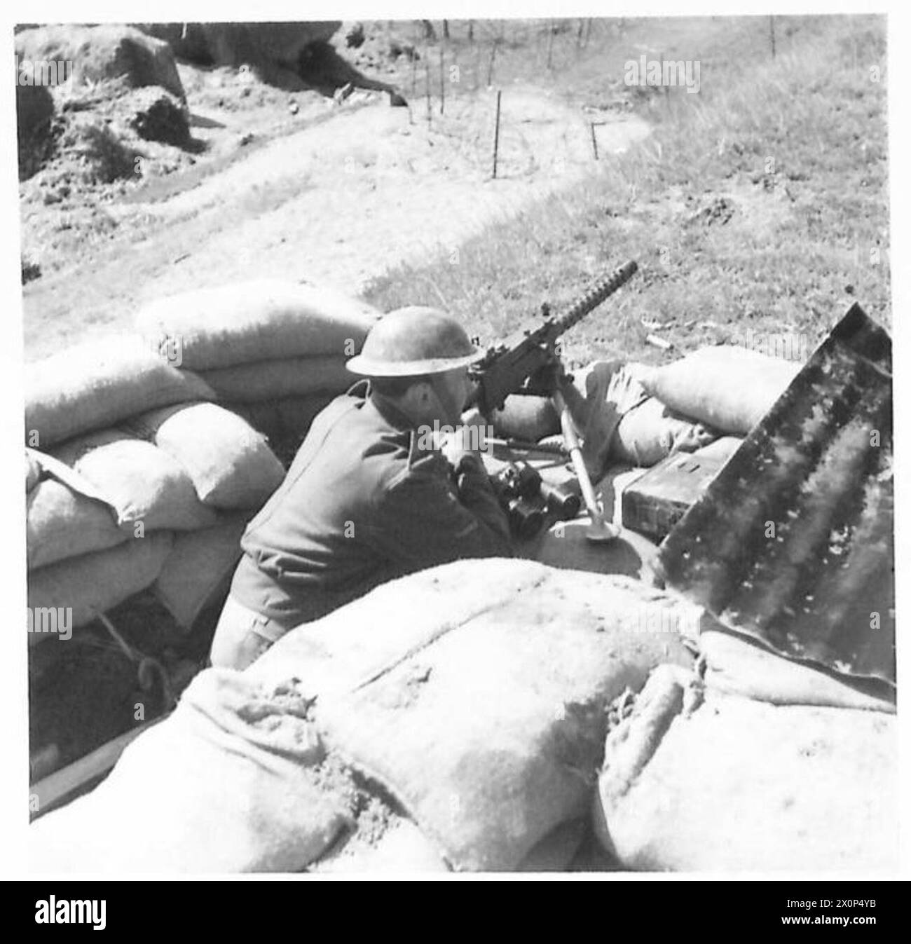 Il caporale T.H. Bates è di guardia con un Browning di 0,5 pollici sulla riva del fiume durante le operazioni dell'esercito britannico in Nord Africa, Sicilia, Italia, Balcani e Austria. Negativo fotografico, British Army. Foto Stock
