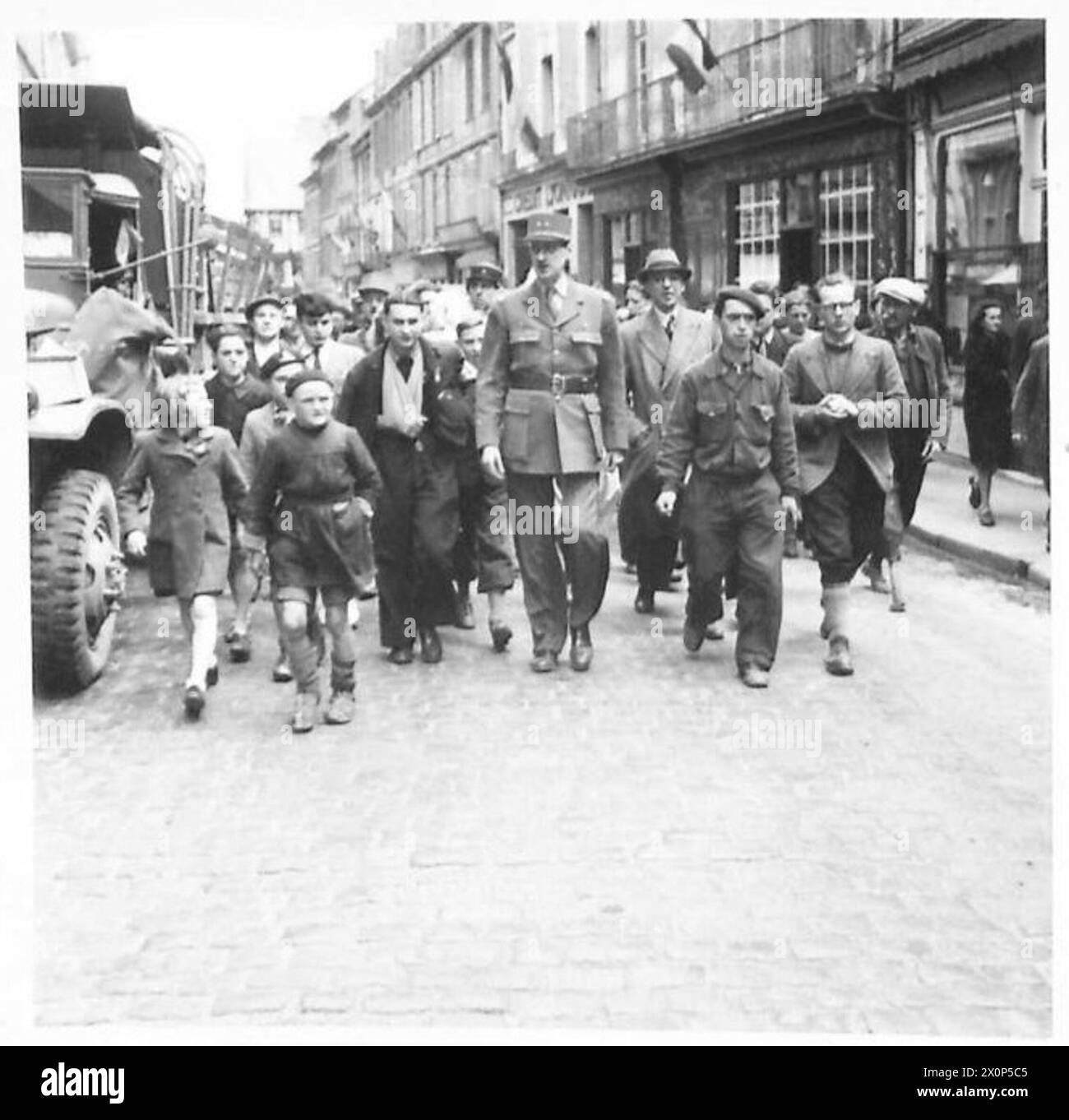 Il generale Charles de Gaulle è seguito da una folla di cittadini francesi mentre cammina per le strade di Bayeux, in Francia, dopo la liberazione. Foto Stock
