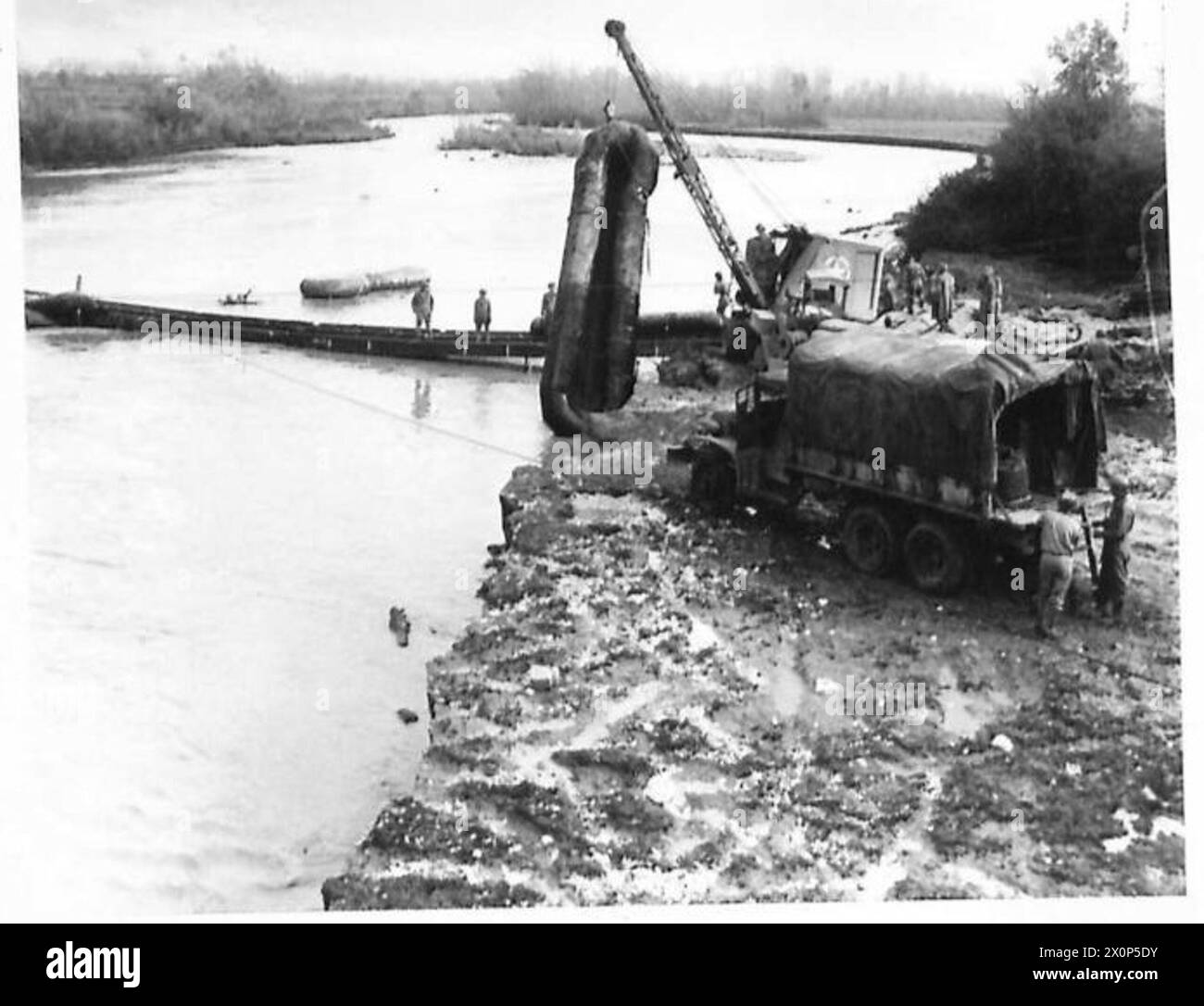 Un carro di recupero solleva un pontone da un fiume in Italia dopo che le inondazioni hanno interrotto i ponti durante le operazioni della Quinta Armata. Foto Stock