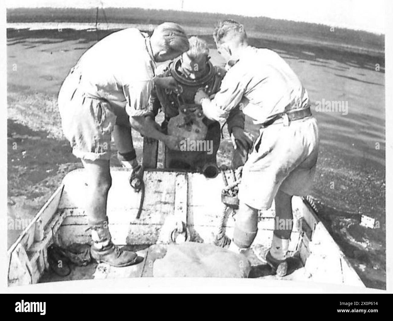 I Royal Engineers preparano un subacqueo attaccando pesi pesanti al petto per le operazioni di immersione durante la seconda guerra mondiale Foto Stock