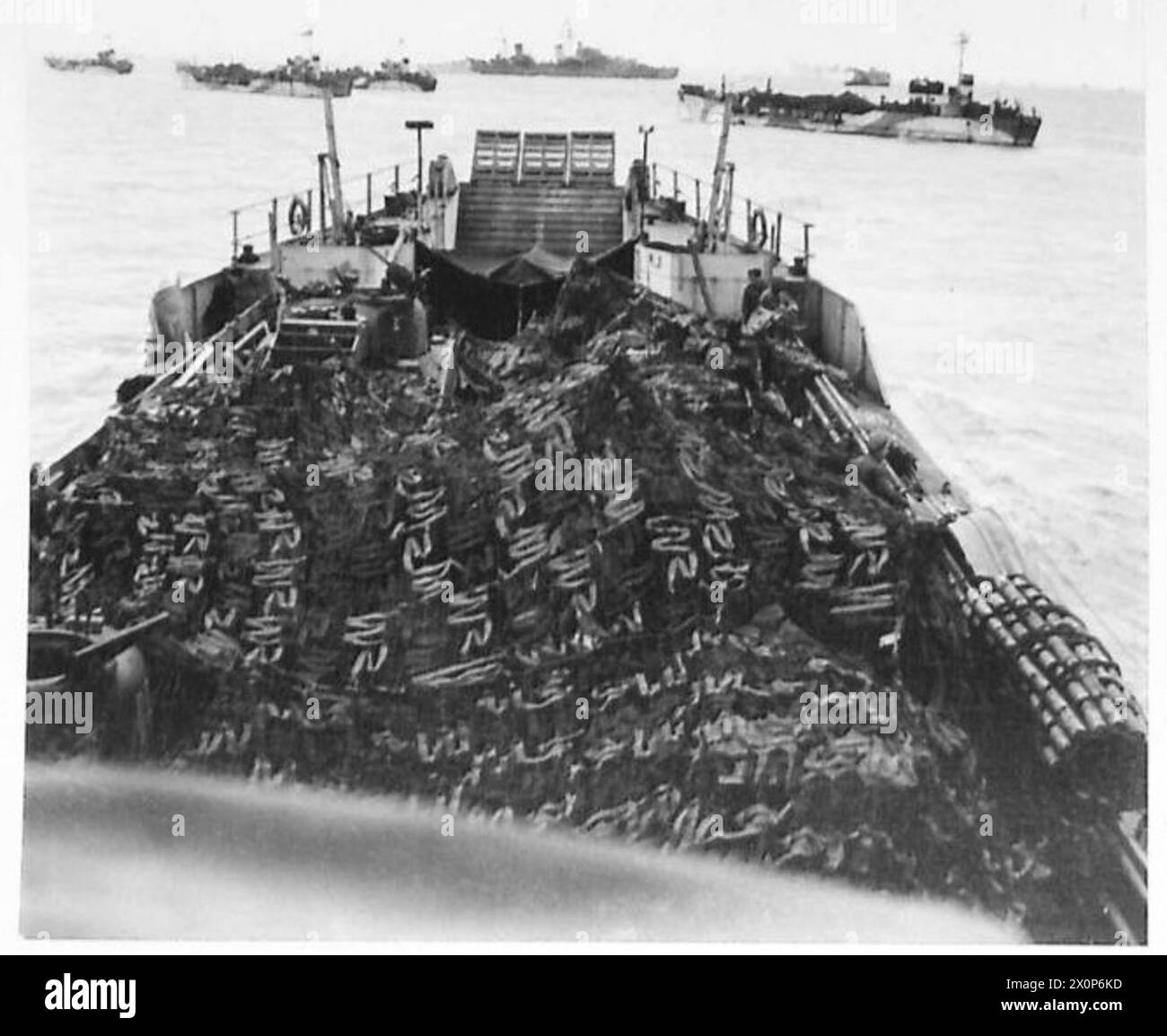 Fotografia del giugno 1944 che mostra carri armati e veicoli del 13°/18° Ussari reali nascosti sotto reti mimetiche sull'LCT 610 mentre i mezzi da sbarco si riuniscono nel Solent al largo di Gosport durante i preparativi del D-Day. Foto Stock