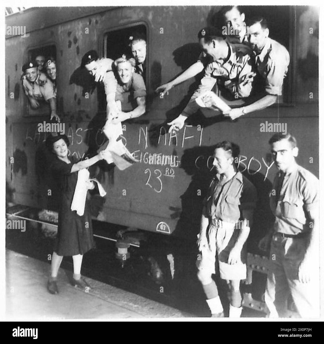 Le truppe acquistano giornali prima di partire con il primo treno in partenza da Milano durante le operazioni dell'esercito britannico in Italia. Foto Stock