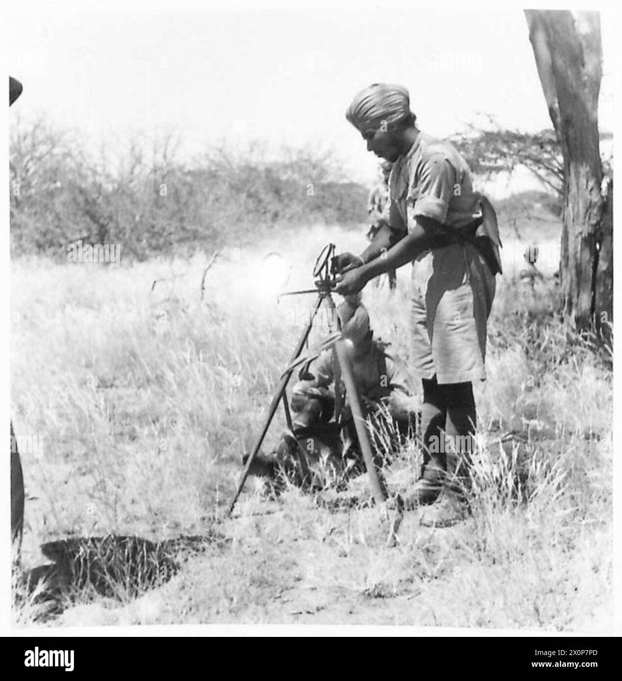 Un operatore di eliografo Sikh della Indian Mountain Battery in Kenya durante la seconda guerra mondiale. L'eliografo, un dispositivo di segnalazione che utilizza specchi e luce solare, è stato impiegato per la comunicazione in aree remote. Le batterie delle Indian Mountain erano parte integrante delle unità di artiglieria britanniche, fornendo supporto mobile su terreni difficili. Negativo fotografico, British Army. Foto Stock