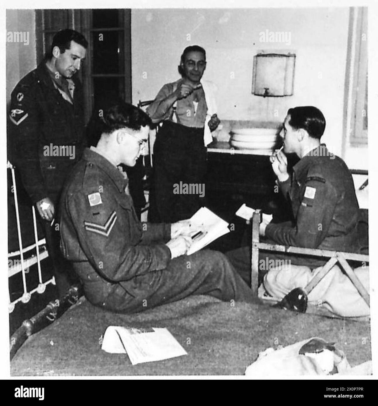 Un SOLDATO GUARDA LA GRECIA - NEL 1946 d.C. : alla fine di una dura giornata di visite turistiche, gli studenti si rilassano nell'hotel di Naupli. Maddox (a destra) studia le sue note; un compagno completa uno schizzo. Negativo fotografico, British Army Foto Stock