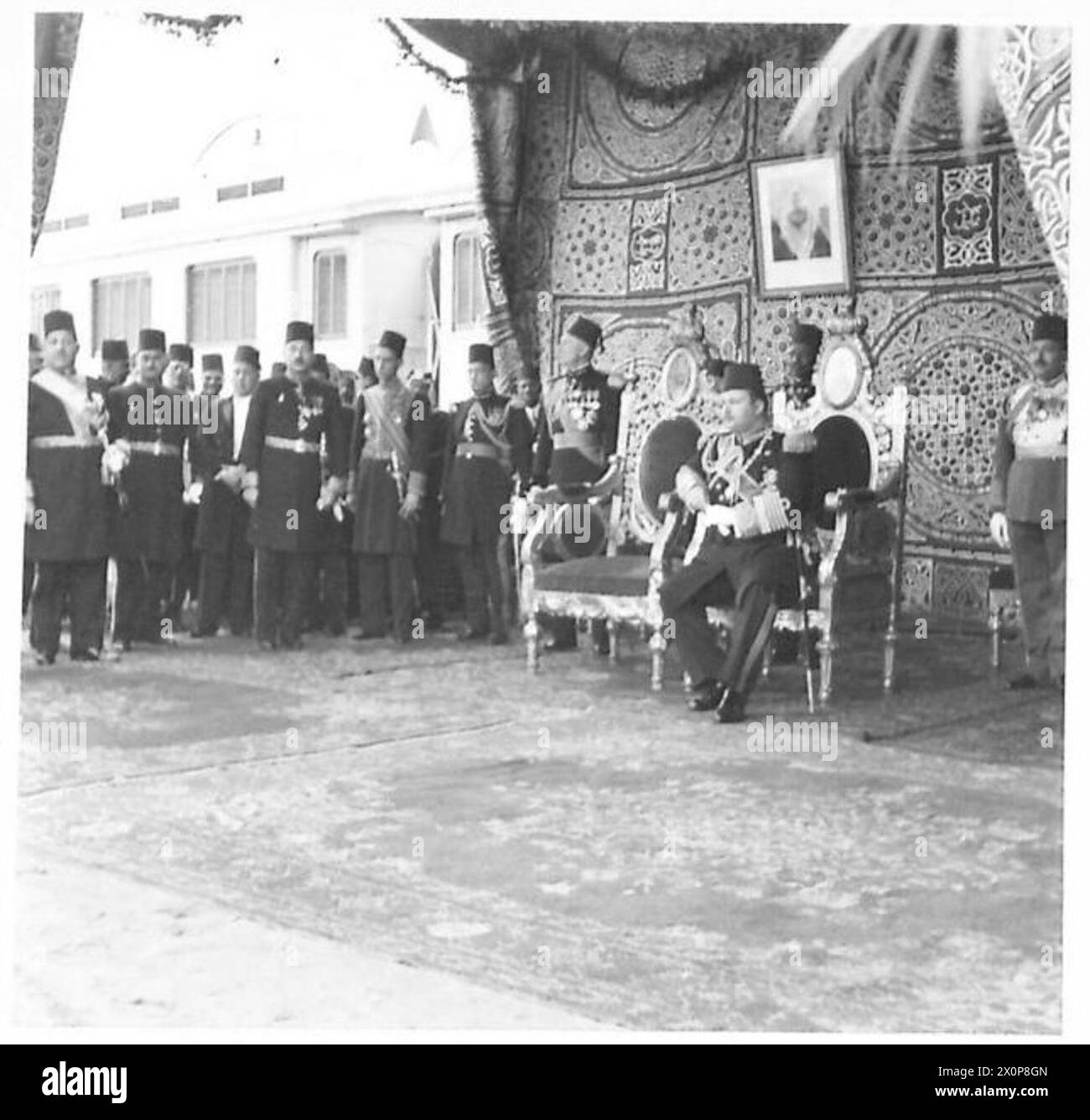 Re Farouk d'Egitto e il suo seguito reale attendono l'arrivo del re 'Abd al-'Aziz Ibn Sa'ud a Port Tewfick in completo abito cerimoniale. Foto Stock