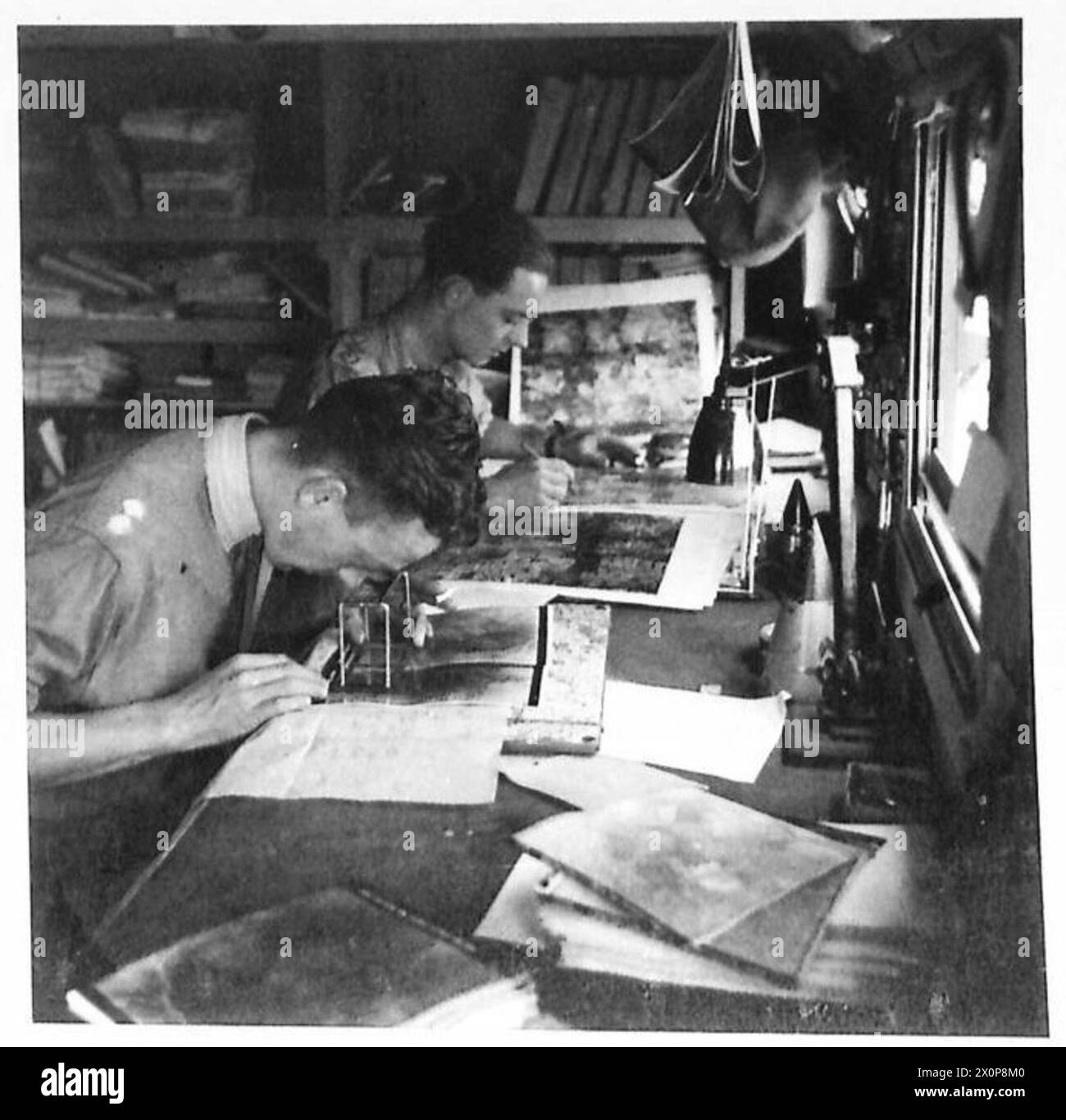 UN QUARTIER GENERALE DEL CORPO. IN FRANCIA - gli interni del Corps Army Photographic Interpretation Section Command Vehicle, che mostra gli ufficiali della sezione che studiano fotografie aeree. La caratteristica principale del lavoro della sezione è interpretare le informazioni di terra dalle fotografie aeree scattate sul fronte del corpo. Negativo fotografico, British Army, 21st Army Group Foto Stock