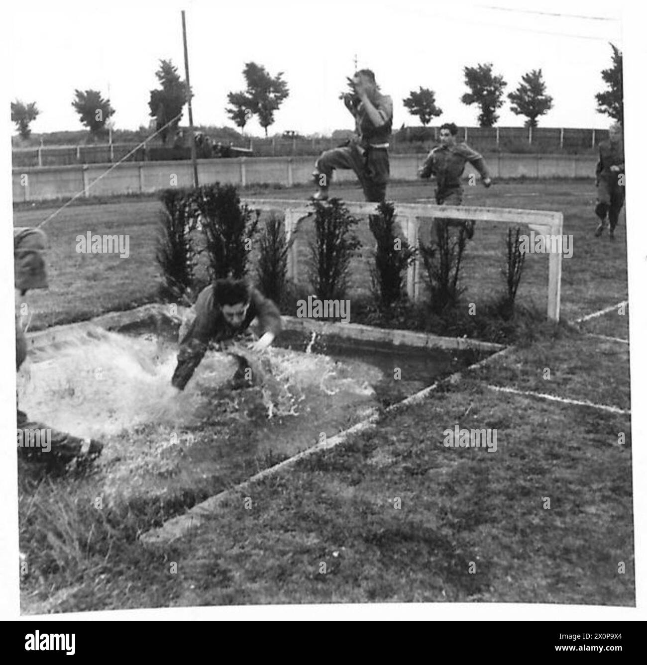 Un concorrente della corsa ad ostacoli AA Regimental Sports Day non riesce a superare un ostacolo ed è inzuppato, British Army. Foto Stock