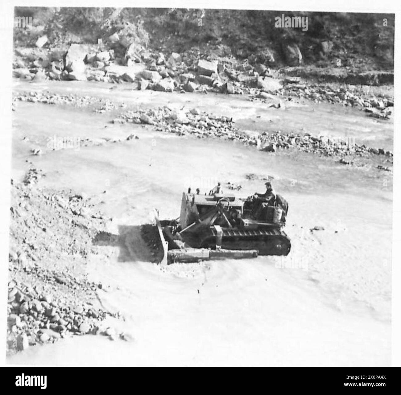Un bulldozer sgombra la ghiaia dal fiume Santerno vicino a Castel del Rio per supportare la manutenzione stradale, illustrando le operazioni dei Royal Engineers con l’Ottava Armata. Foto Stock