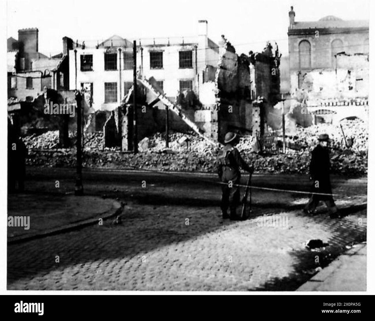 Un soldato lavora per eliminare i danni provocati da bombe in un'area sbiadita di Belfast. Foto Stock