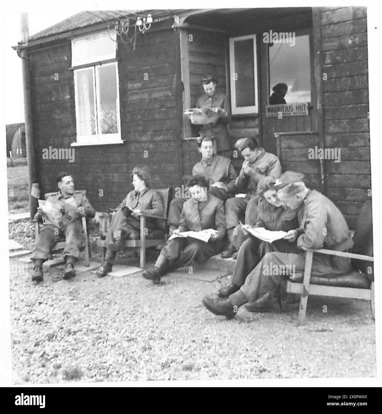 Il personale antiaereo è radunato fuori da una capanna ricreativa su un sito di armi, impegnato in una conversazione. Foto Stock