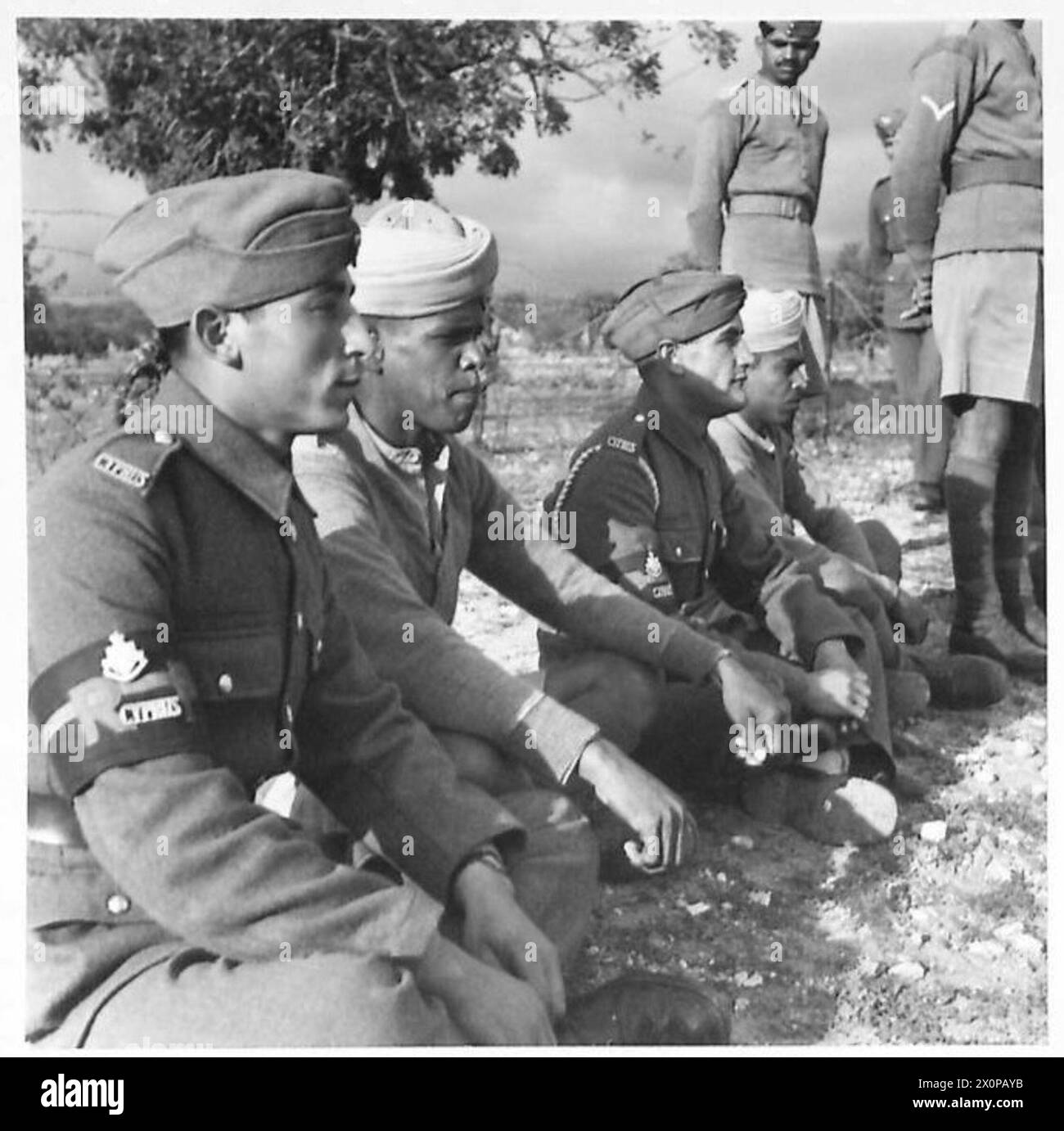 Gli spettatori indiani e ciprioti si siedono insieme a guardare una partita di calcio a Cipro, dimostrando l'interazione civile locale durante la guerra. Foto Stock