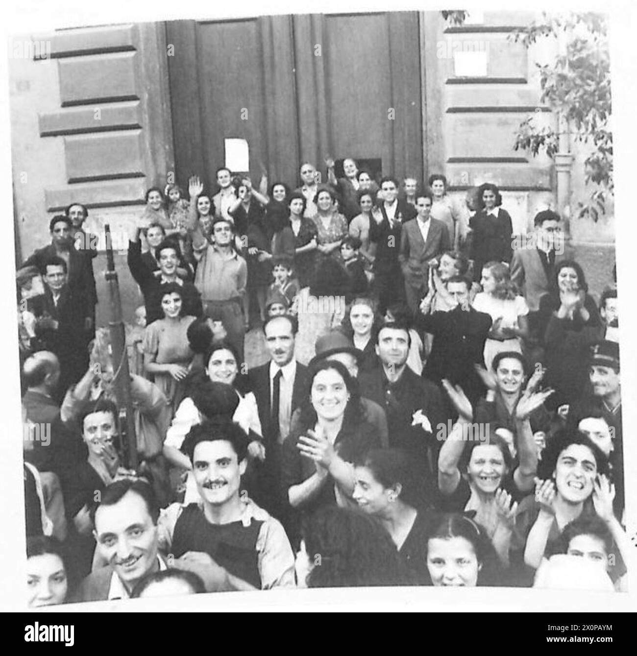 Durante l'entrata della Quinta Armata a Napoli, i civili italiani applaudono e salutano le truppe britanniche dopo aver resistito alle forze tedesche e fasciste. Il negativo fotografico registra l'interazione. Esercito britannico. Foto Stock
