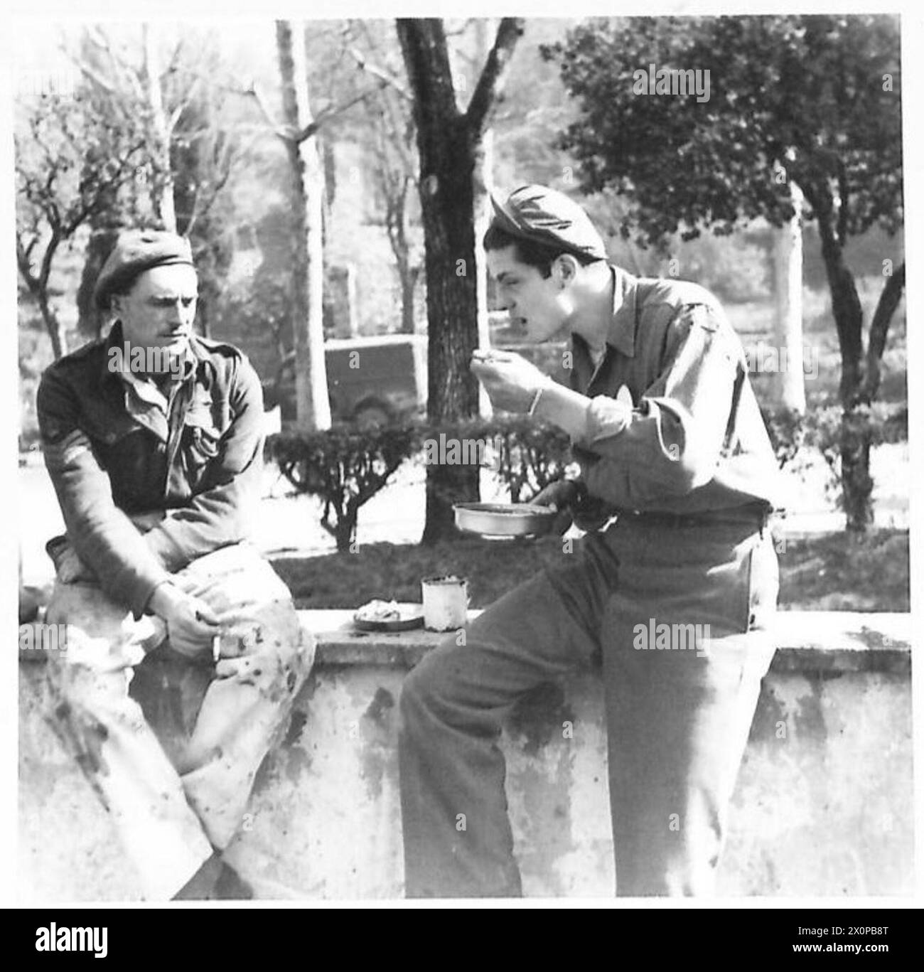 Il sergente Harry Burrows e George Couriskey dell'American Field Service condividono il pranzo con l'ottava armata, documentando la vita quotidiana e le attività di supporto. Negativo fotografico dell'esercito britannico. Foto Stock