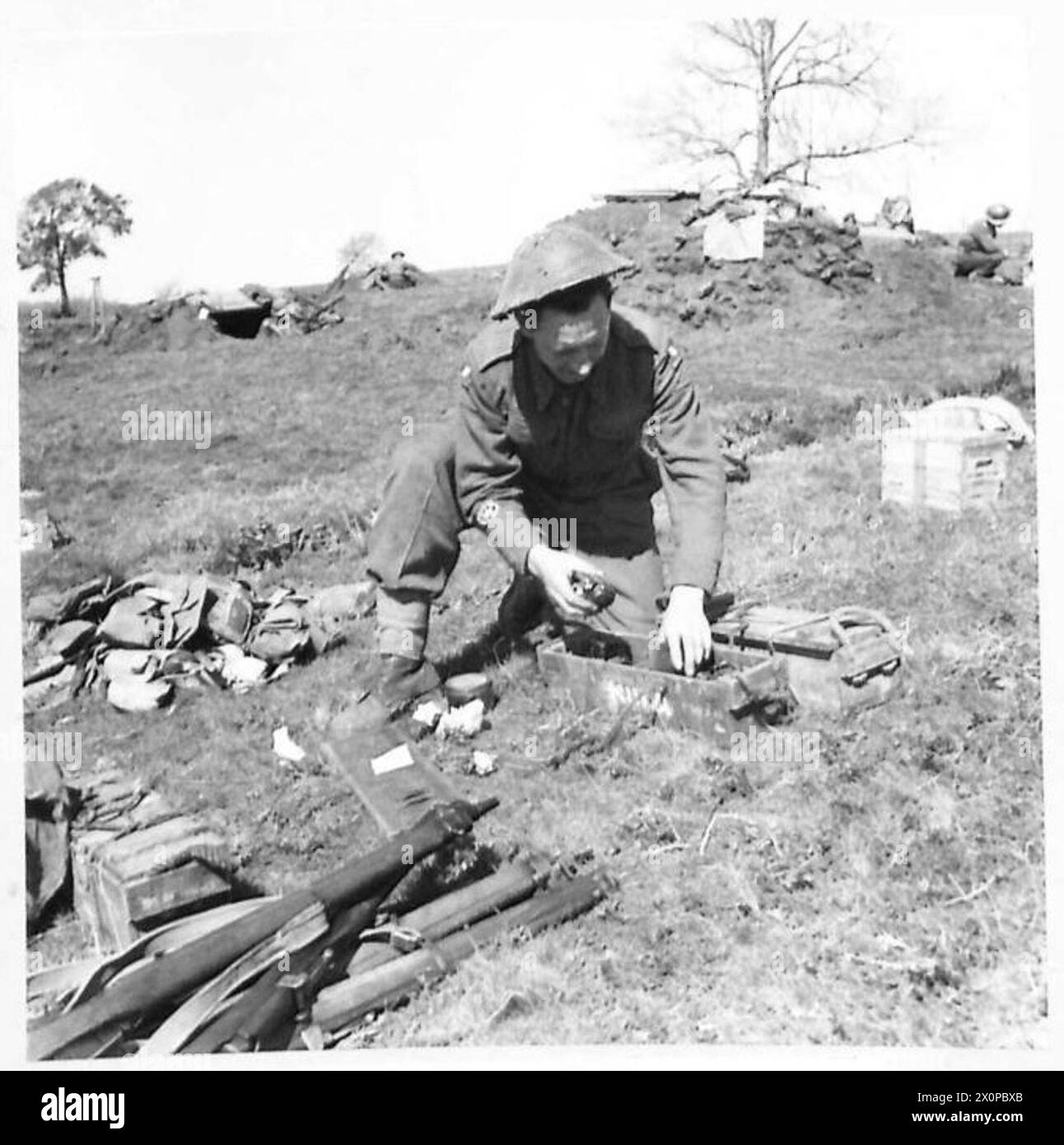 Il battaglione irlandese a testa di ponte di Anzio celebra il giorno di San Patrizio, mentre il sergente maggiore della compagnia ispeziona le granate a mano. Negativo fotografico dell'esercito britannico. Foto Stock