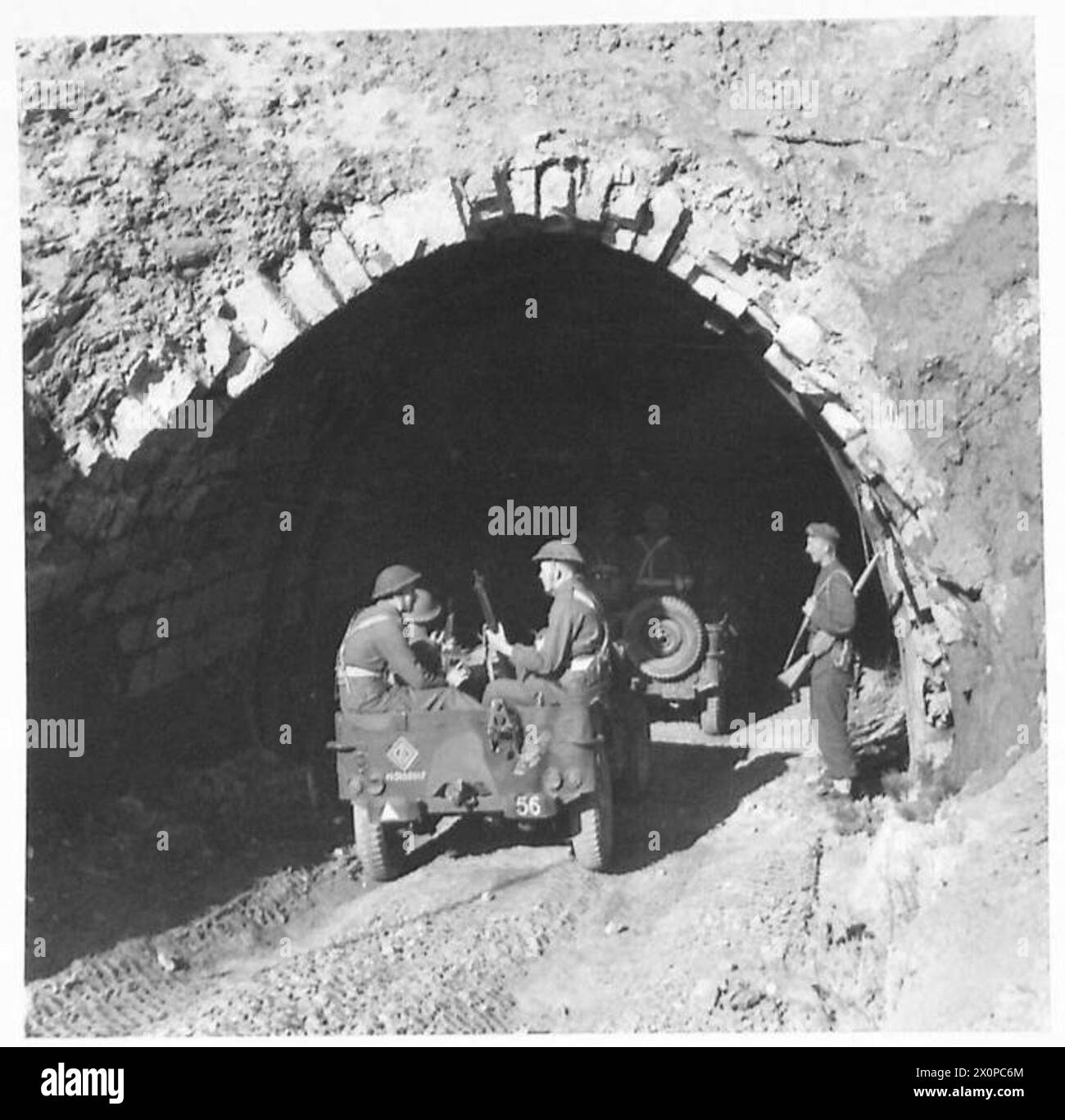 La fanteria in jeep entra in un tunnel di 3 miglia verso una città in prima linea in Italia, con il movimento ritardato fino alla notte a causa dell'osservazione nemica. Negativo fotografico dell'esercito britannico. Foto Stock