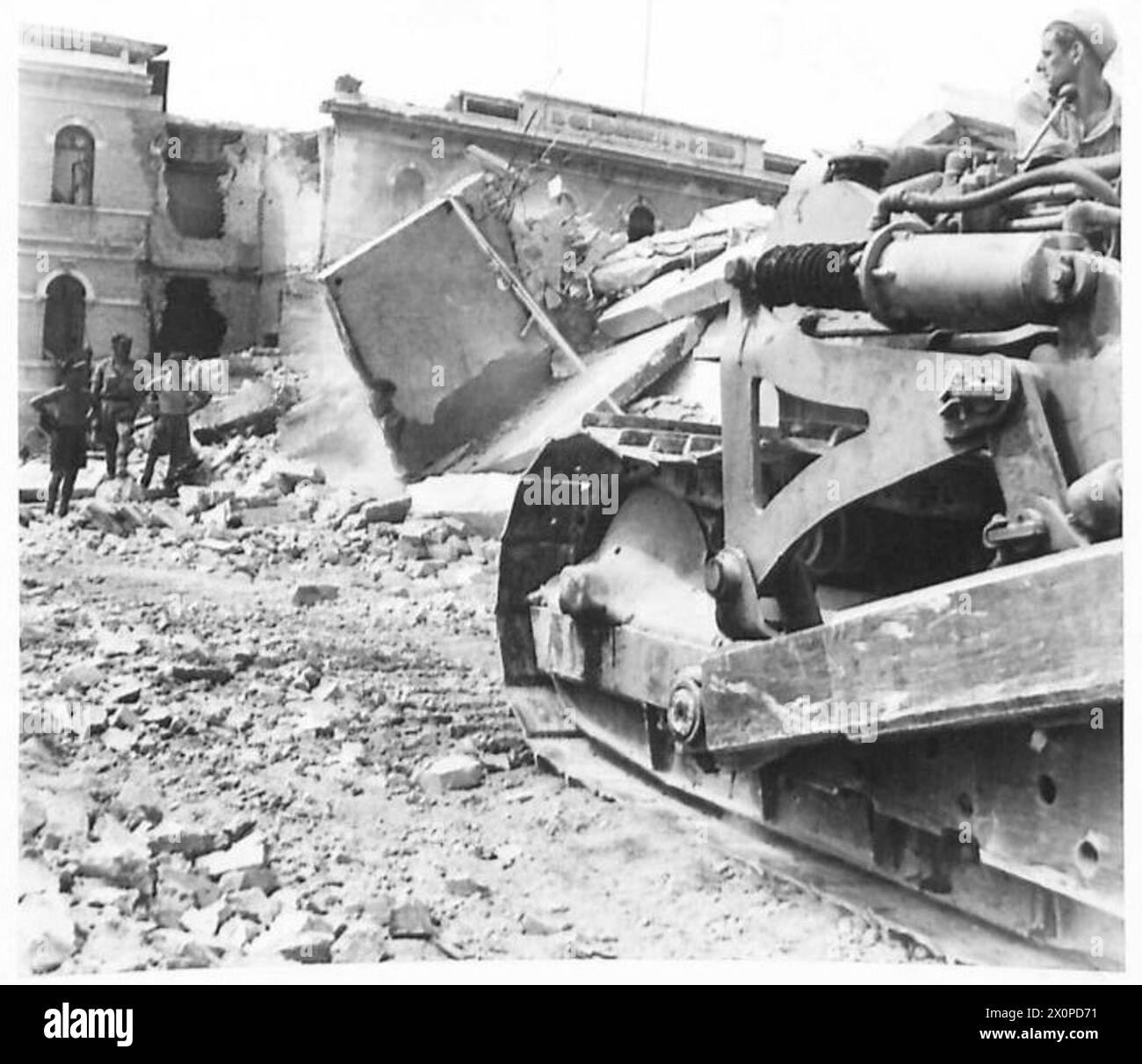 I bulldozer eliminano i detriti sulla banchina mentre i negozi navali arrivano ad Ancona per le operazioni dell'Ottava Armata in Italia. Foto Stock