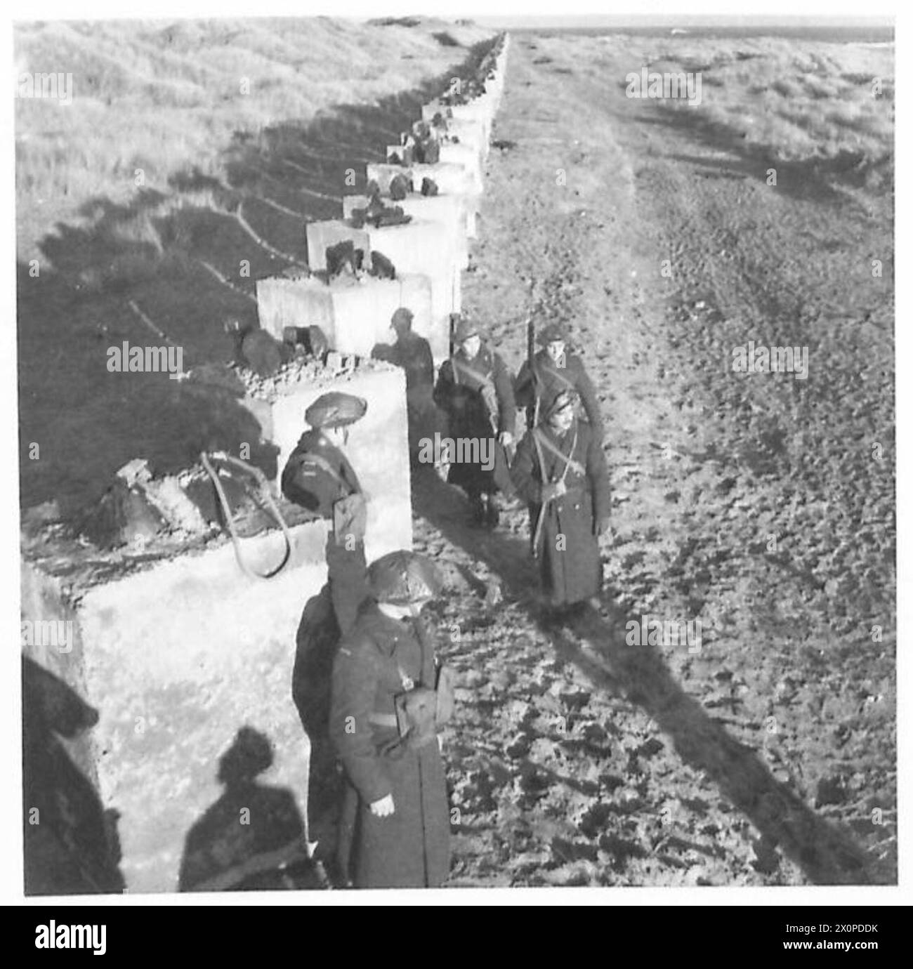 Una pattuglia del i corpo polacco si muove con difese costiere concrete a Carnoustie il 22 novembre 1940. Foto Stock