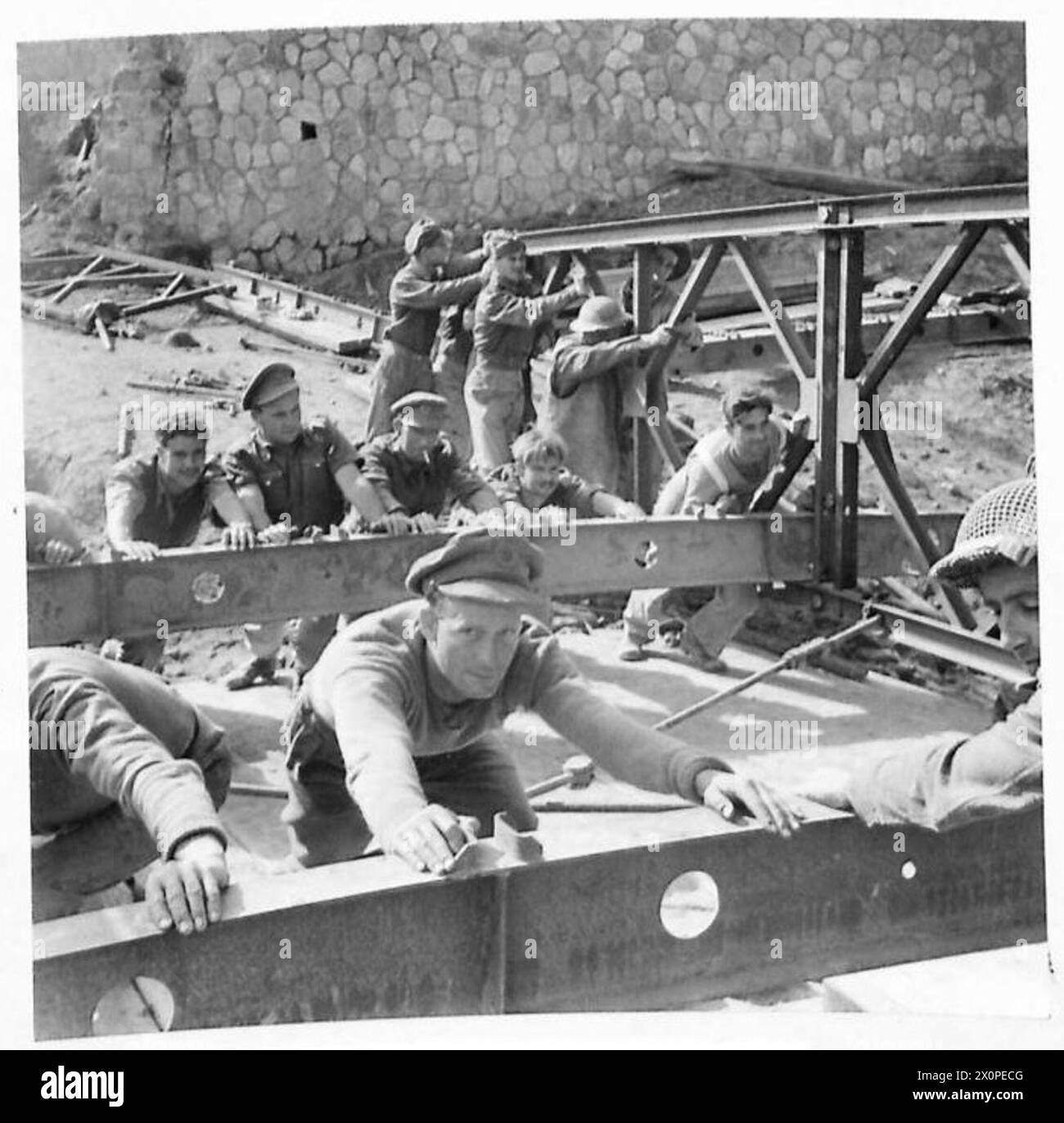 Fotografia di ingegneri reali della Quinta Armata che costruiscono un ponte sul fiume Volturno in Italia, utilizzando parti di un vecchio ponte tedesco. Foto Stock