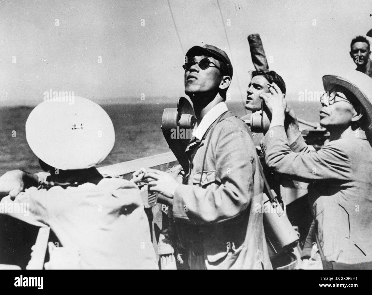 LA HMS DUKE OF YORK SI SPOSTA VERSO TOKYO. 27 AGOSTO 1945, A BORDO DELLA HMS DUKE OF YORK. QUANDO I GIAPPONESI FIRMARONO I TERMINI DI RESA ALLEATI A BORDO DELLA USS MISSOURI NELLA BAIA DI TOKYO, LA HMS DUKE OF YORK, AMMIRAGLIA DELL'AMMIRAGLIO SIR BRUCE FRASER, C IN C DELLA FLOTTA BRITANNICA DEL PACIFICO, ERA AL FIANCO. - Pilota giapponese (a destra) e interprete sul ponte della HMS DUKE OF YORK mentre si dirigeva verso il suo ancoraggio Foto Stock