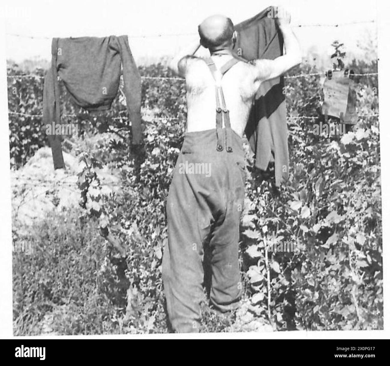 Rudolf Greishammer, un dottore in filosofia dell'Università di Jena in Turingia, Germania, serve come fante tedesco arruolato durante il 1942-1946, visto ispezionare la sua uniforme. Foto Stock