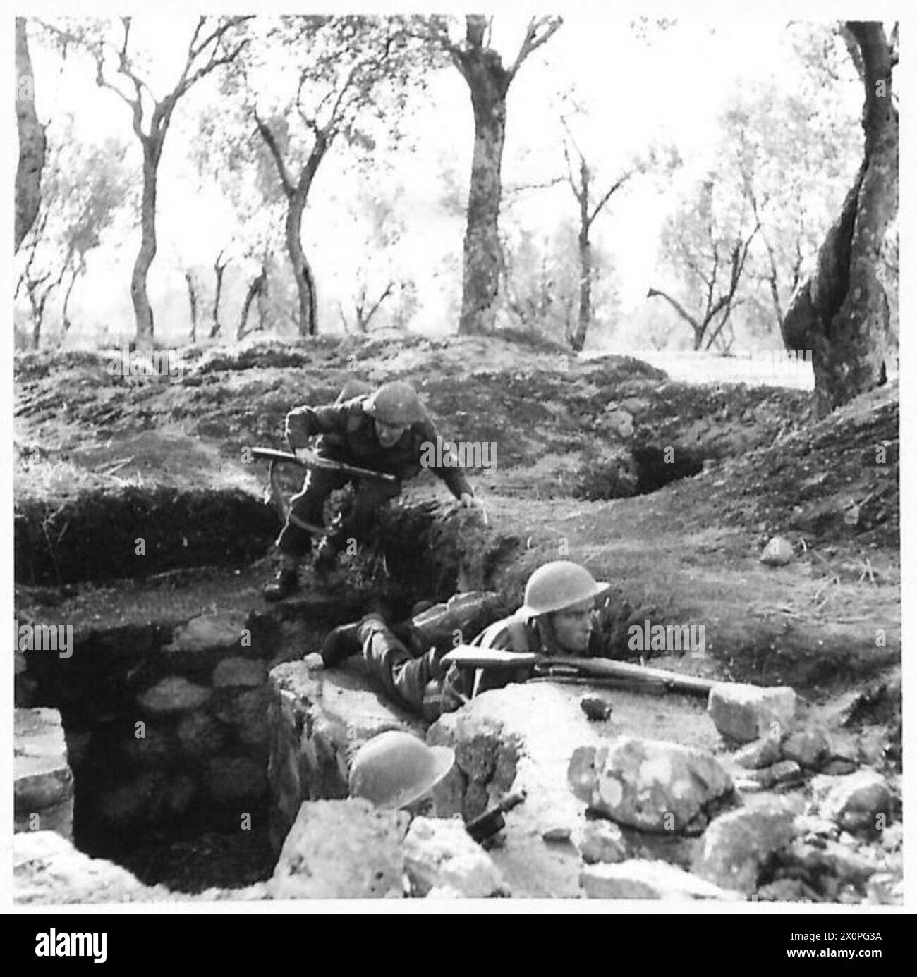 Un soldato della Quinta Armata salta da una trincea in una postazione di osservazione in avanti durante una pattuglia di battaglia in Italia, illustrando le operazioni in prima linea. Foto Stock