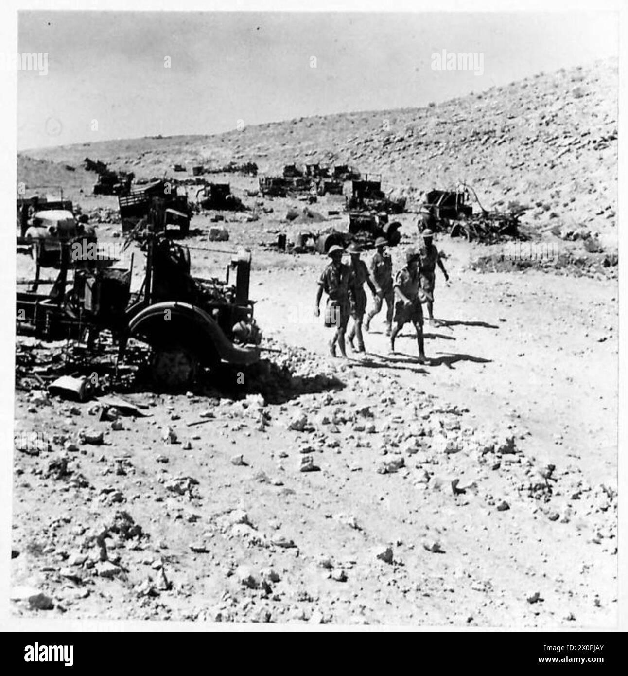 Una collezione di veicoli da trasporto italiani distrutti è osservata in un deposito di relitti a Tobruk. Foto Stock