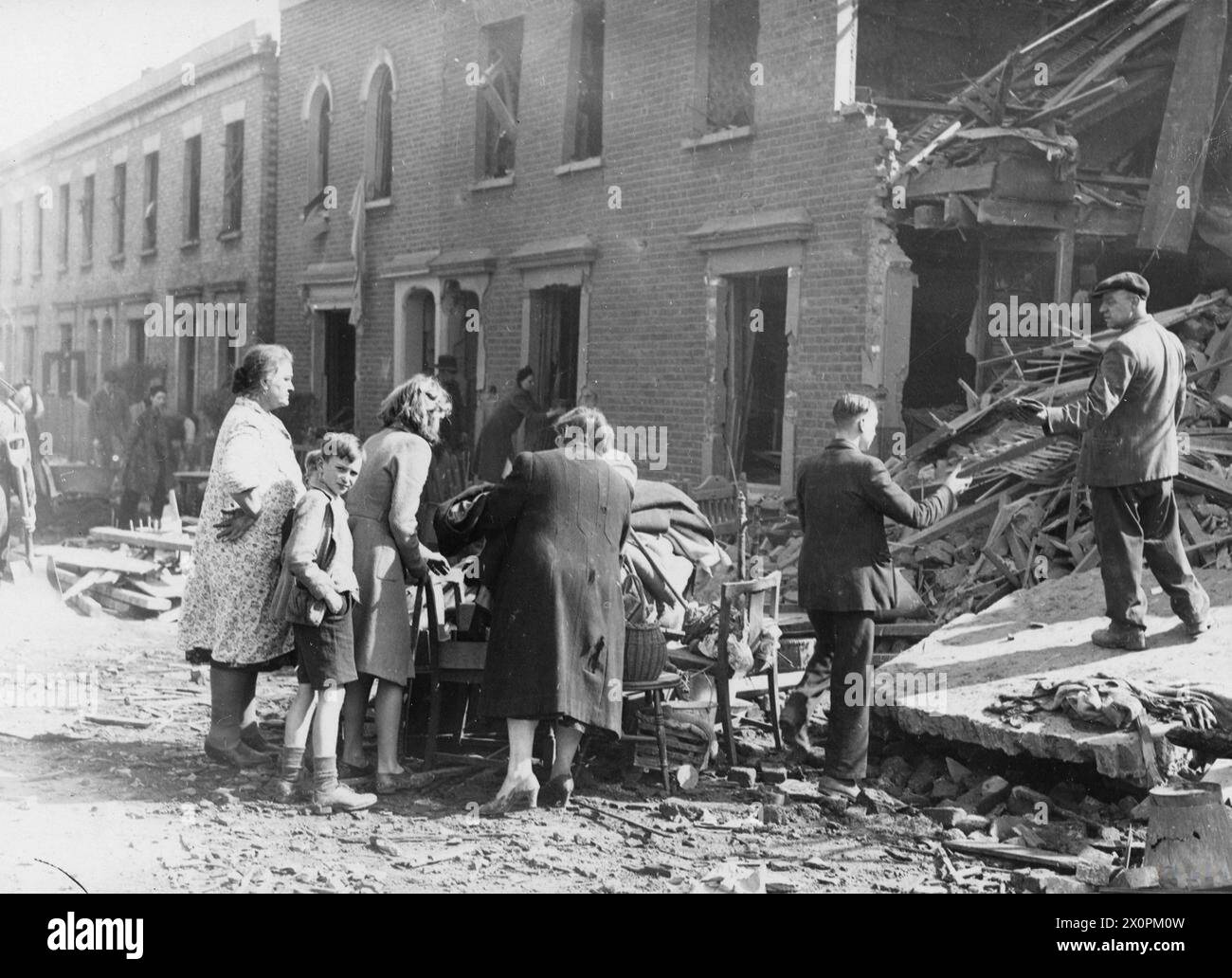 Le persone in una strada di Londra raccolgono oggetti domestici da case danneggiate da bombe a East Surrey Grove, 17-18 maggio 1943. Negativo fotografico, British Army. Foto Stock