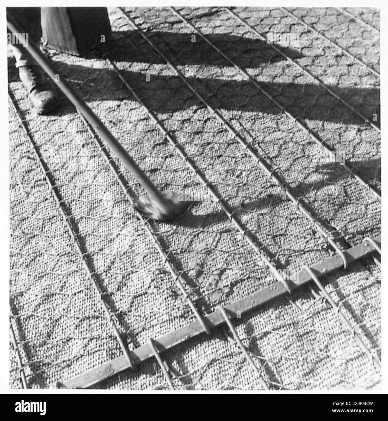 Un primo piano di un aeroporto avanzato in costruzione mostra il processo di mimetizzazione e la composizione dettagliata della pista. Foto Stock