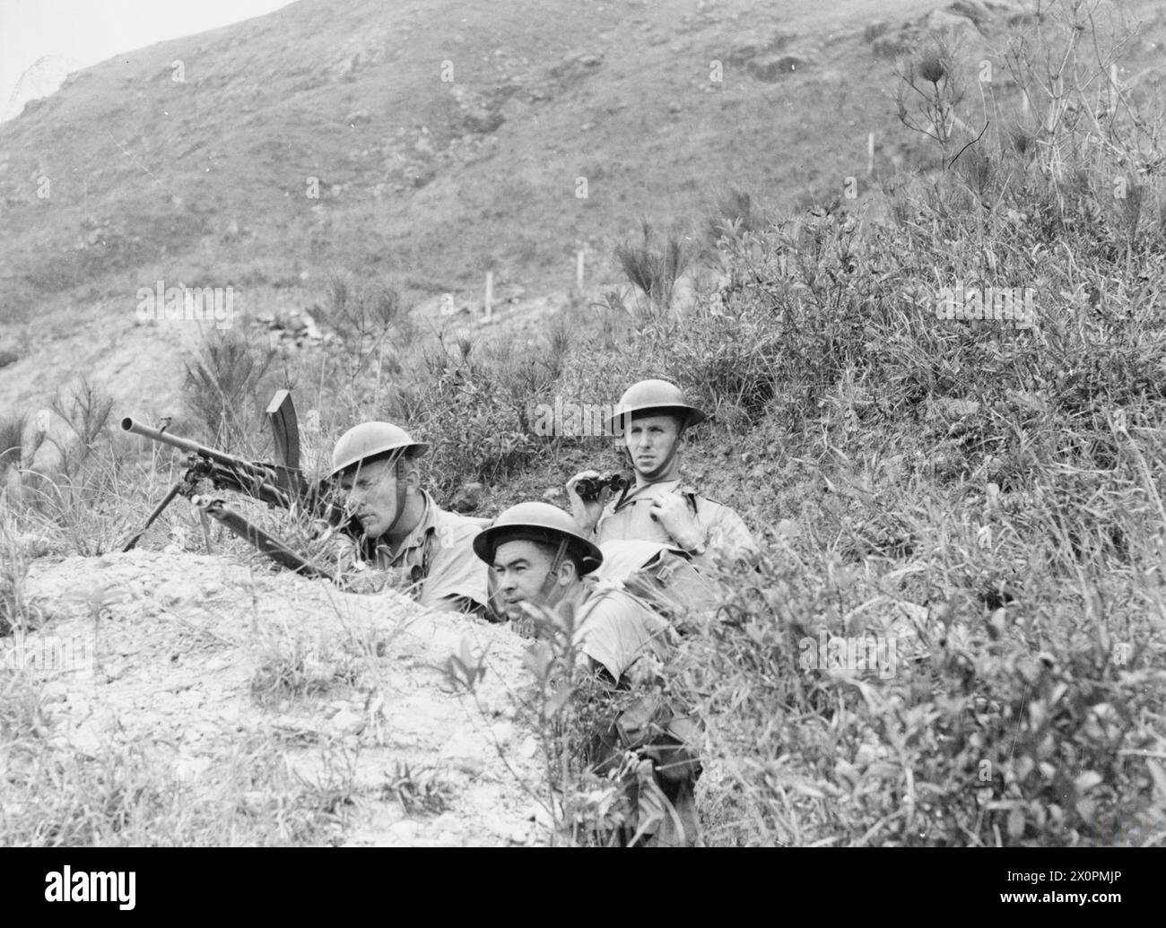 Le truppe canadesi sono posizionate tra le colline di Hong Kong prima della caduta della colonia nel 1941. La fotografia documenta lo spiegamento delle truppe, il terreno e il posizionamento pre-battaglia durante la seconda guerra mondiale Foto Stock