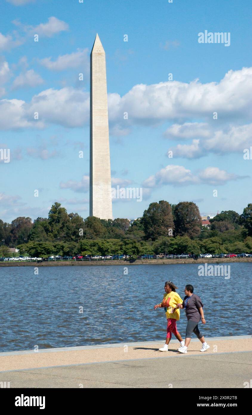Donne che camminano di fronte al Washington Monument USA Foto Stock