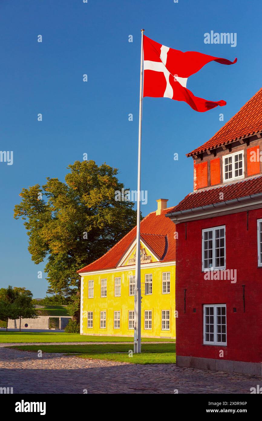 La bandiera danese ondeggia sulla caserma reale al tramonto a Copenaghen, Danimarca, al Parco Kronprinsessegade Foto Stock