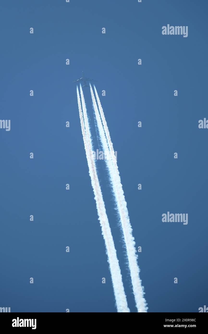 Aereo nel cielo blu con contrail Foto Stock