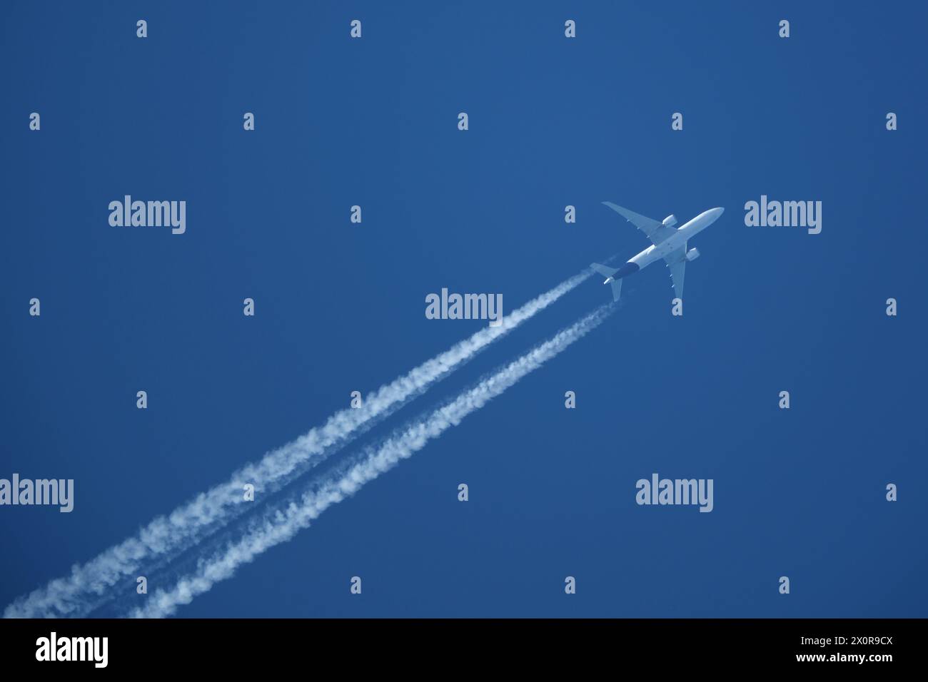 Aereo nel cielo blu con contrail Foto Stock