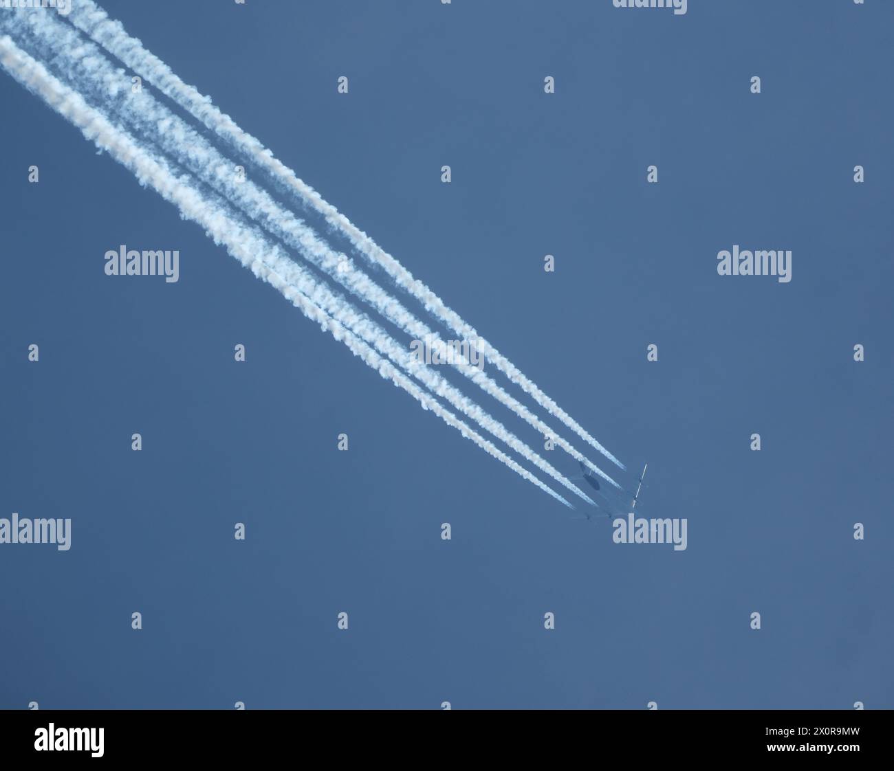 Aereo nel cielo blu con contrail Foto Stock