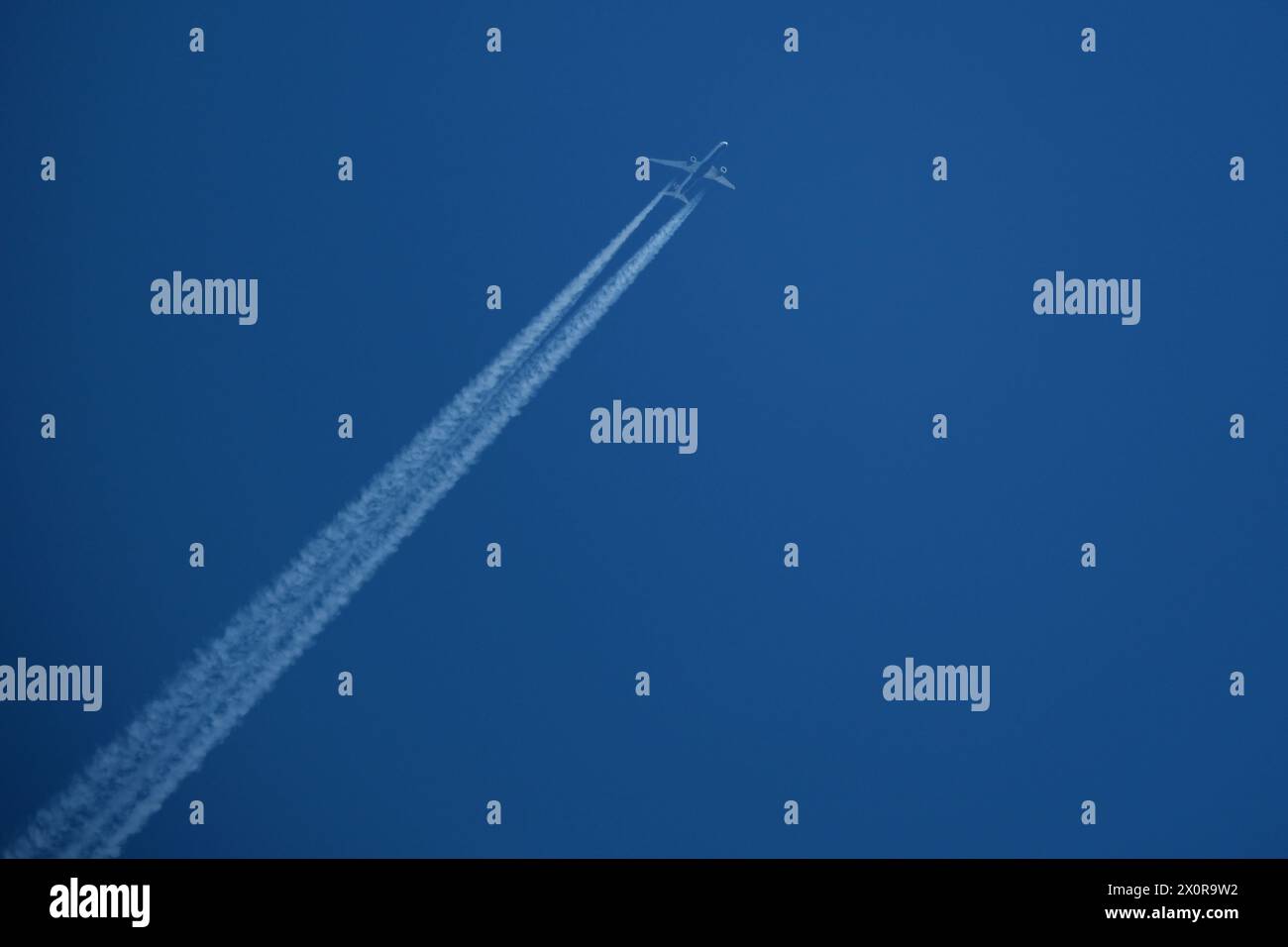 Aereo nel cielo blu con contrail Foto Stock