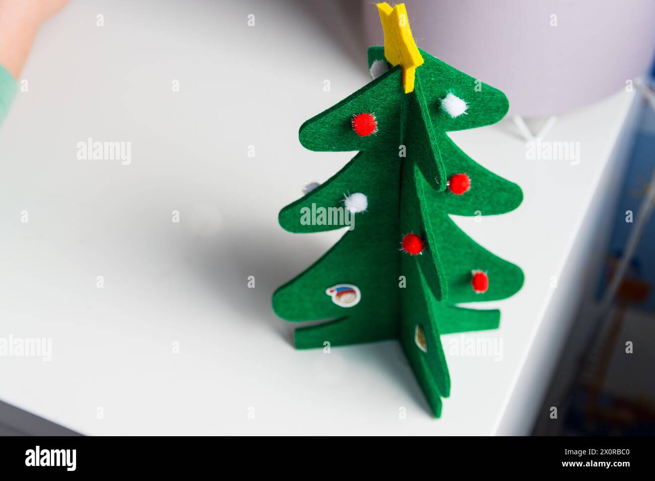 L'albero di natale fatto a mano rimane sul tavolo nella stanza dei bambini. Decorazione di giocattoli di Natale per biglietti d'auguri. Buon Natale e felice anno nuovo decorazione Foto Stock