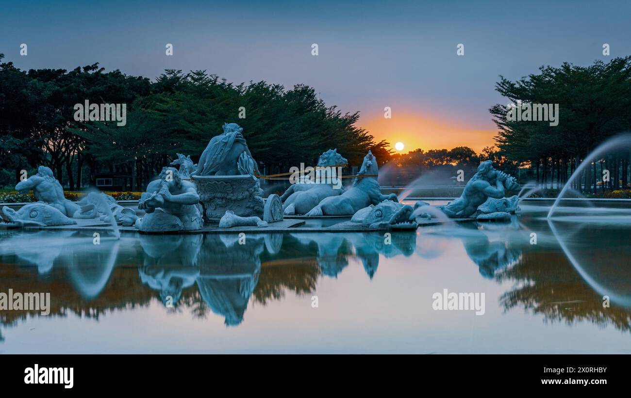 Scenario al tramonto della piazza della fontana di Apollo e riflessi nel giardino pubblico all'aperto del Museo chi Mei a Tainan, nel sud di Taiwan. Foto Stock