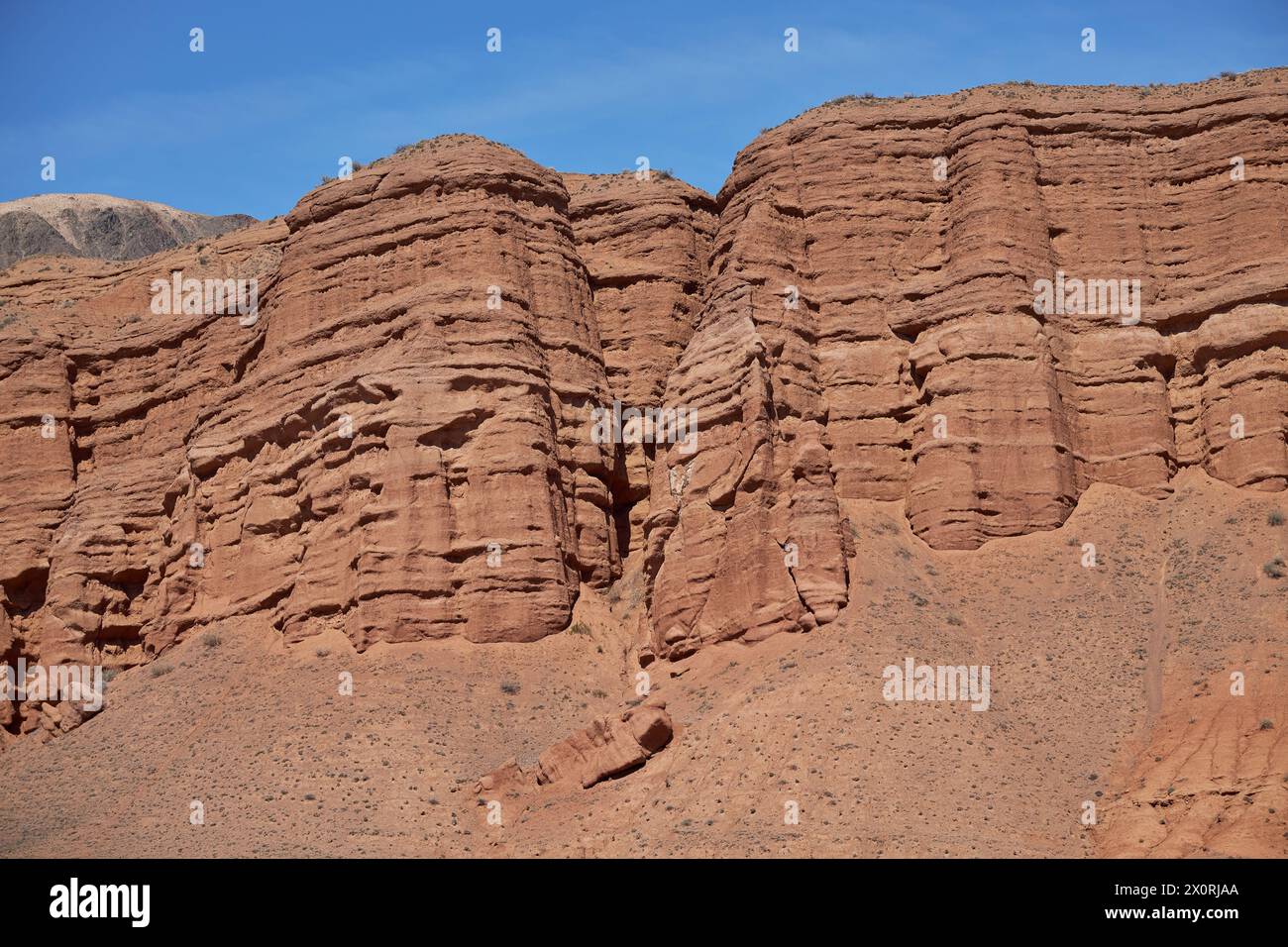 Destinazione di viaggio, famoso punto di riferimento del Kirghizistan. Colonne rocciose di arenaria rossa nel canyon di Konorchek, depositi eolici, scogliere a picco causate da erosioni del suolo Foto Stock