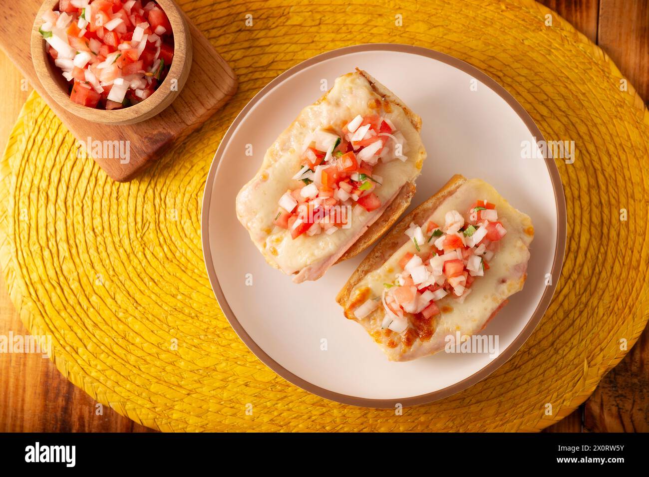 Molletes. Ricetta messicana a base di bolillo spaccato longitudinalmente, spalmare con fagioli fritti e formaggio gratin, aggiungendo la salsa pico de gallo e un po' di pro Foto Stock